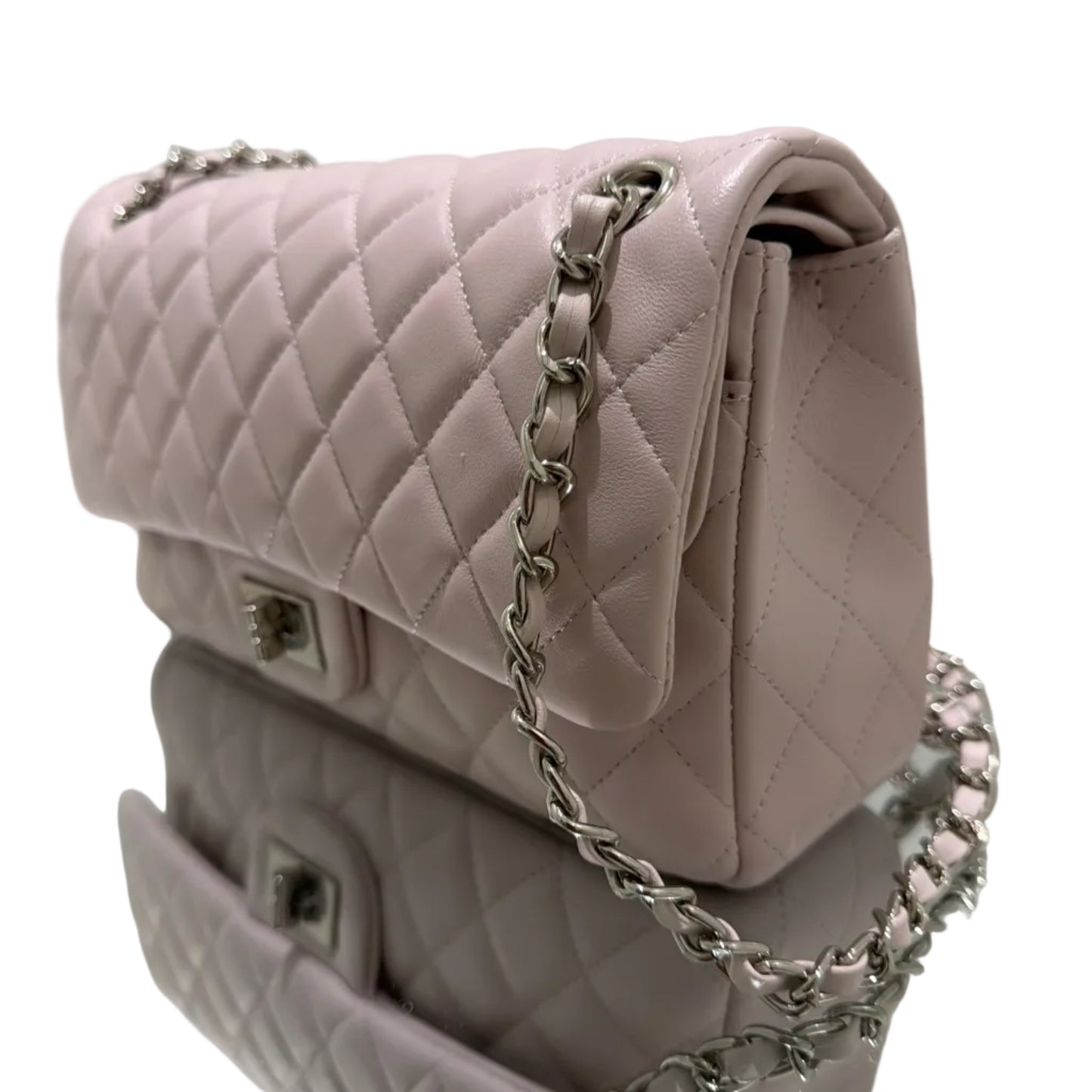 Pink quilted handbag with a chain strap on a white surface
