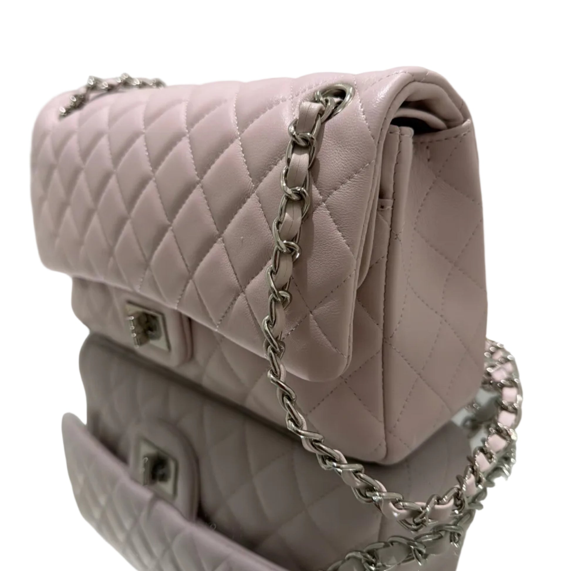 Pink quilted handbag with a chain strap on a white surface