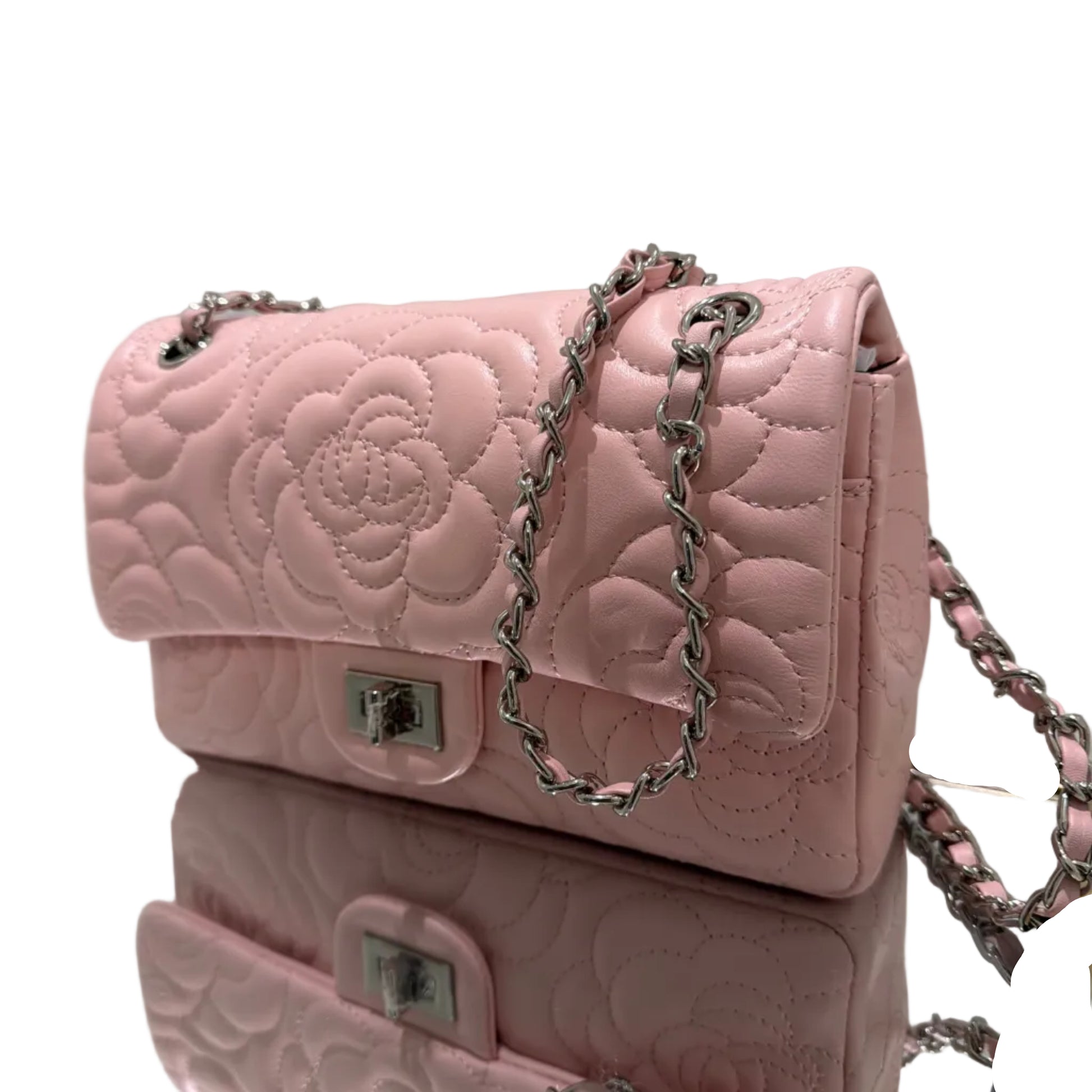 Pink quilted handbag with floral design and chain strap on a white background