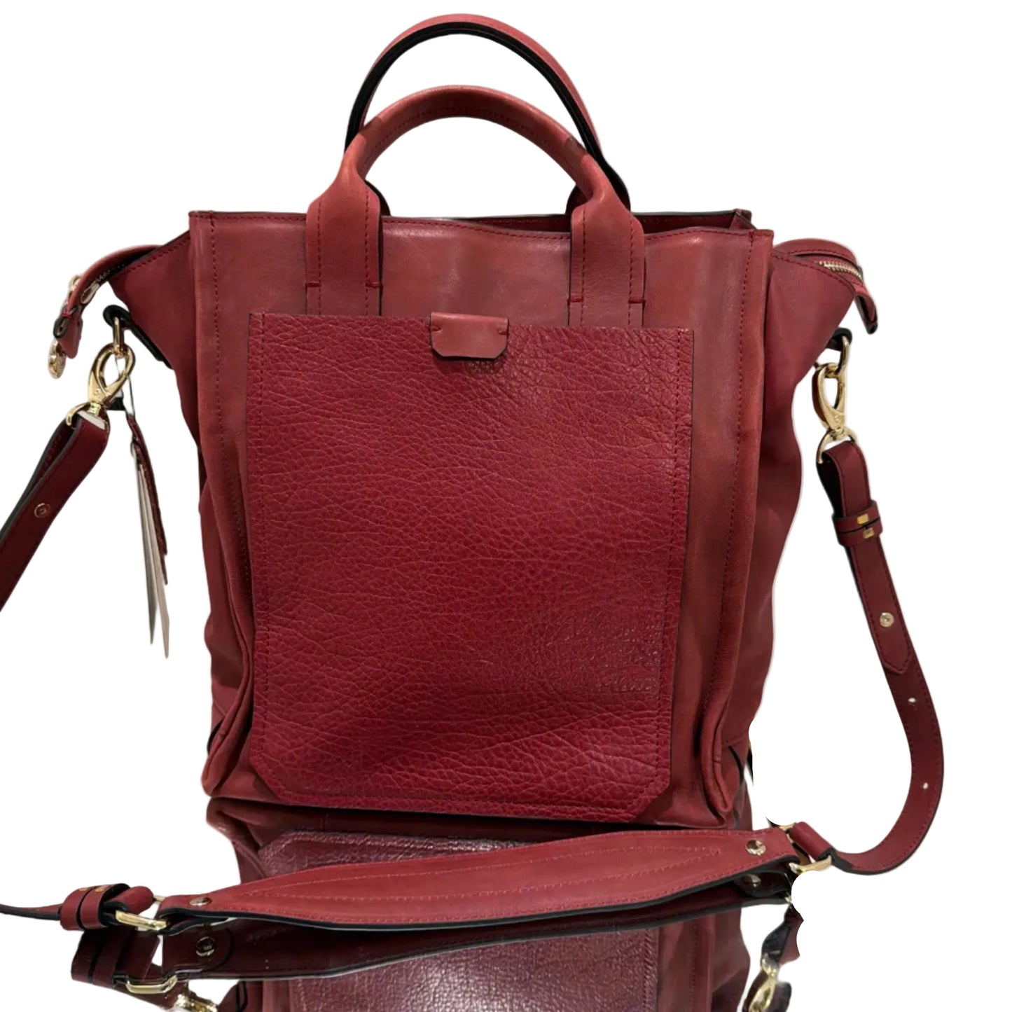 Red leather handbag on a white surface with a gold frame