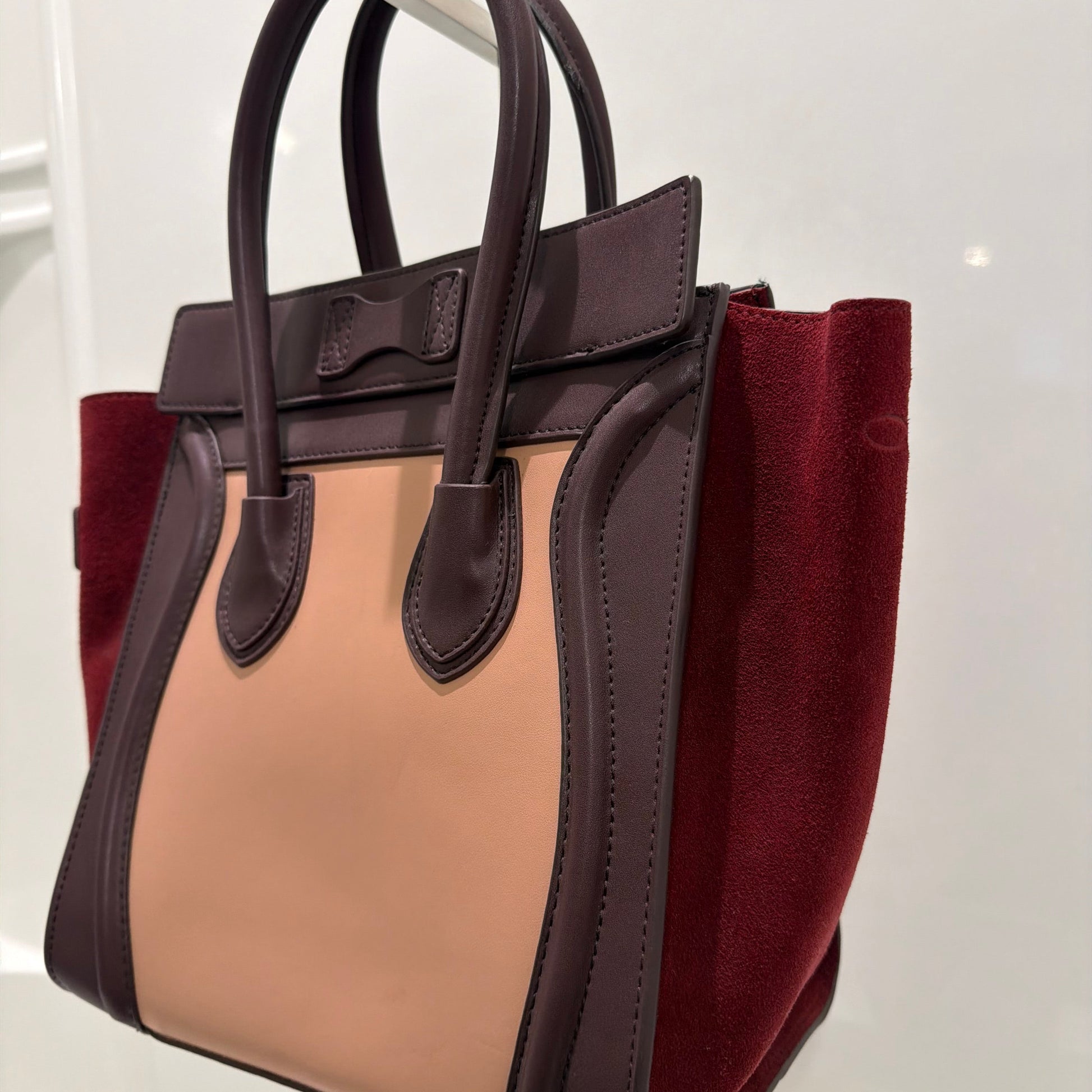 Designer handbag with burgundy and beige colors on a white background
