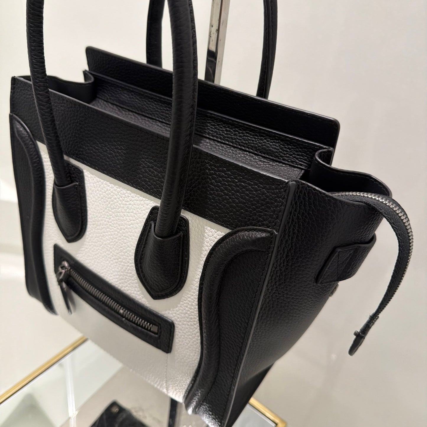 Black leather handbag with a reflective surface on a white background