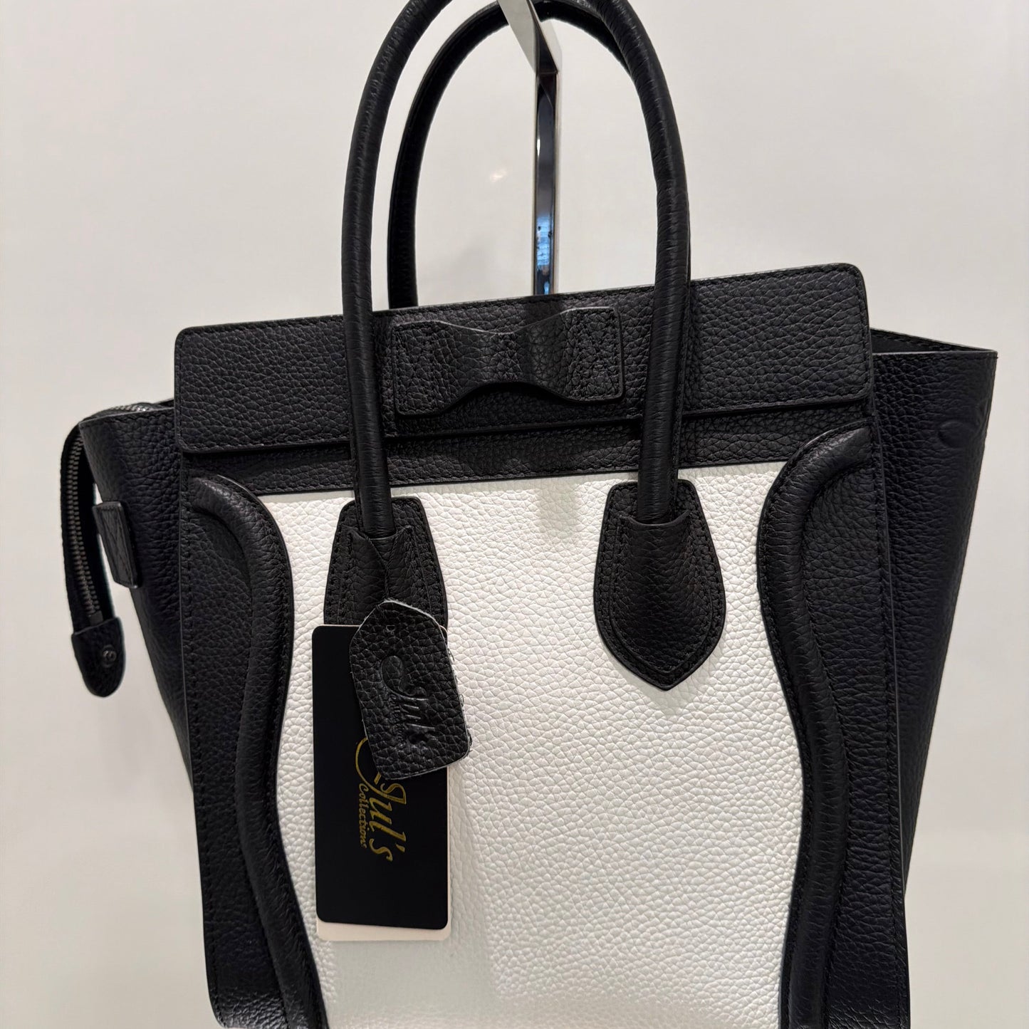 Black leather bag with visible brand logo on a light gray background
