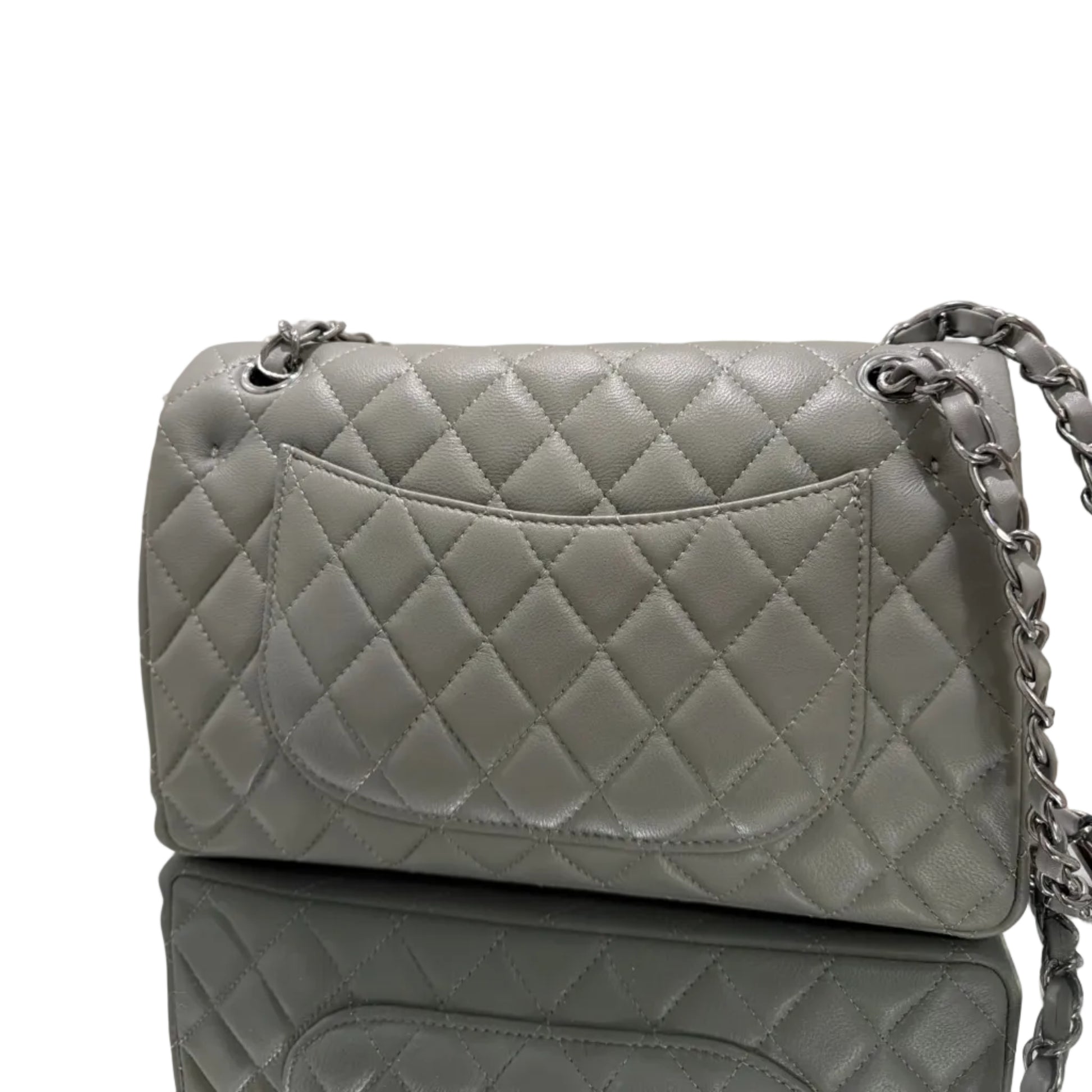 Gray quilted handbag with a chain strap on a light background