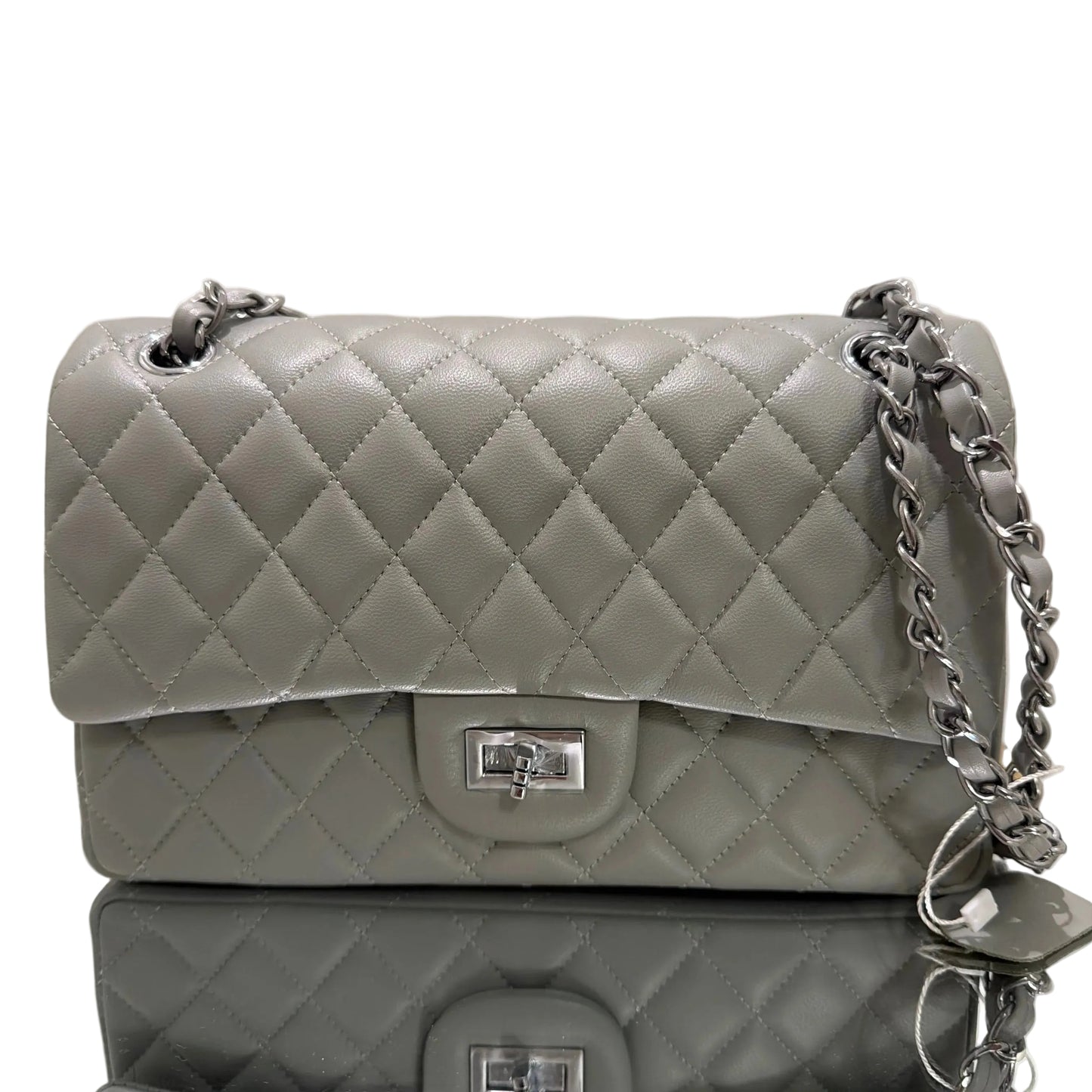 Two gray quilted handbags with silver chains on a beige background