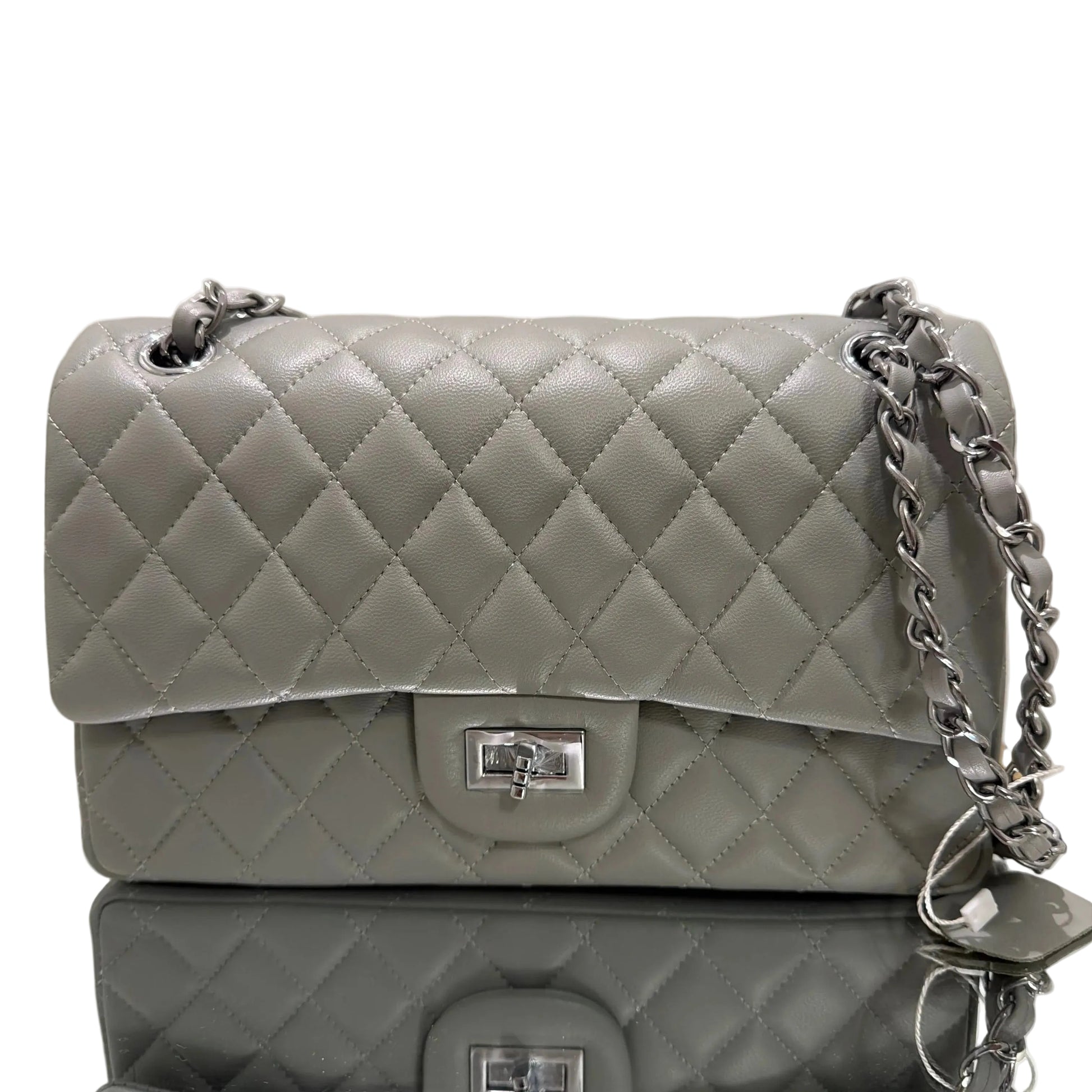 Two gray quilted handbags with silver chains on a beige background