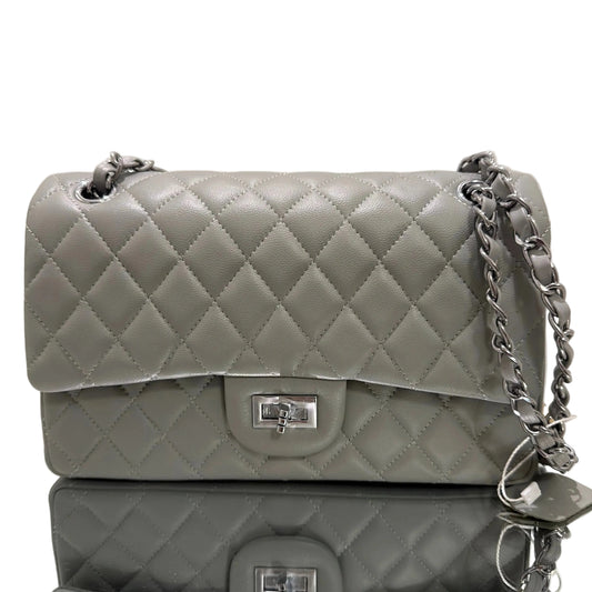 Two gray quilted handbags with silver chains on a beige background