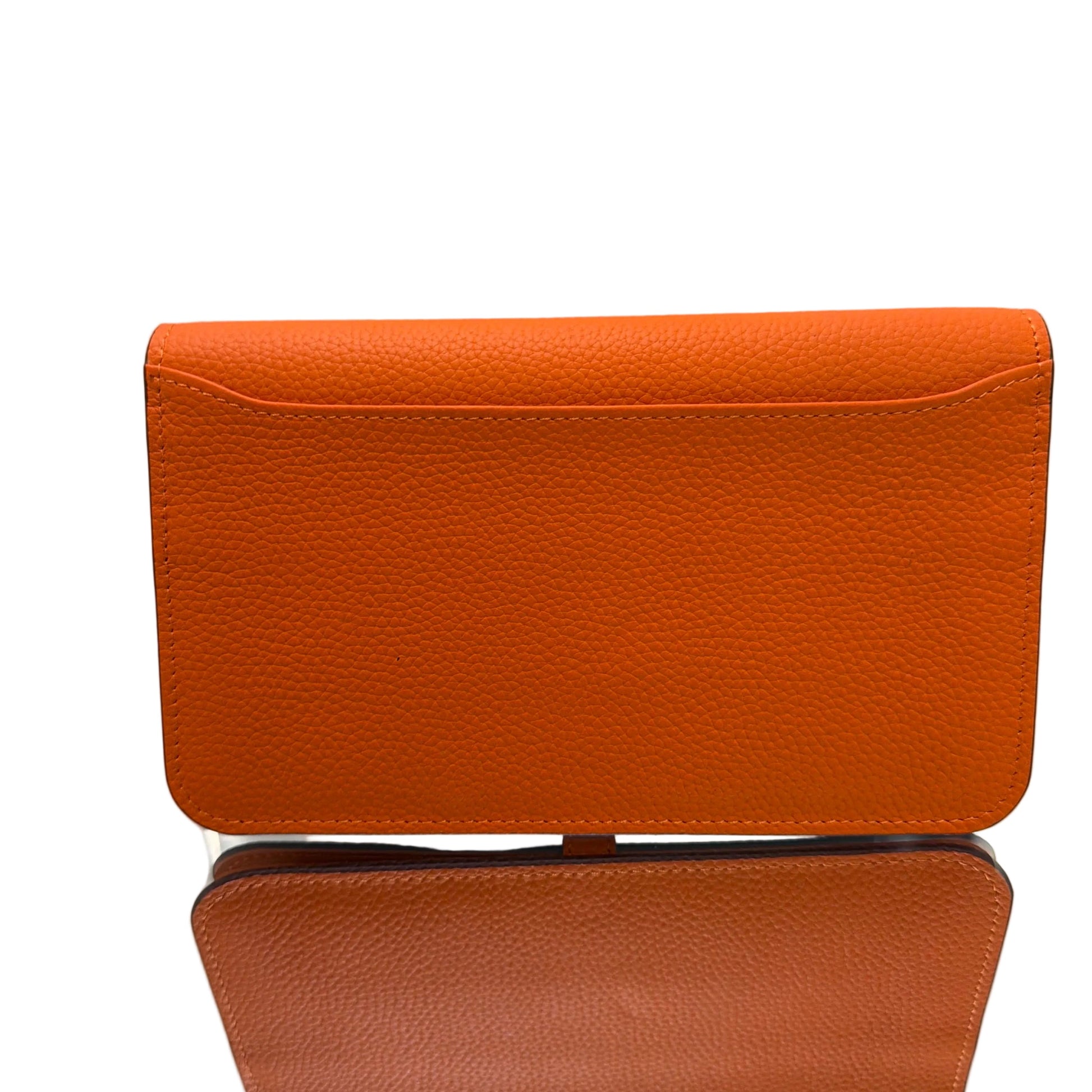 Two orange leather cases on a light gray background