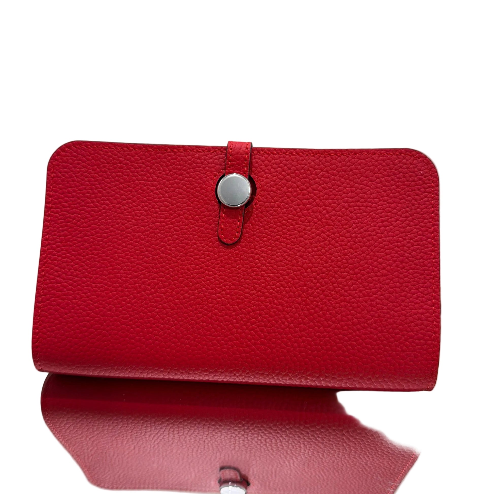 Red leather wallet with a silver buckle on a light gray background