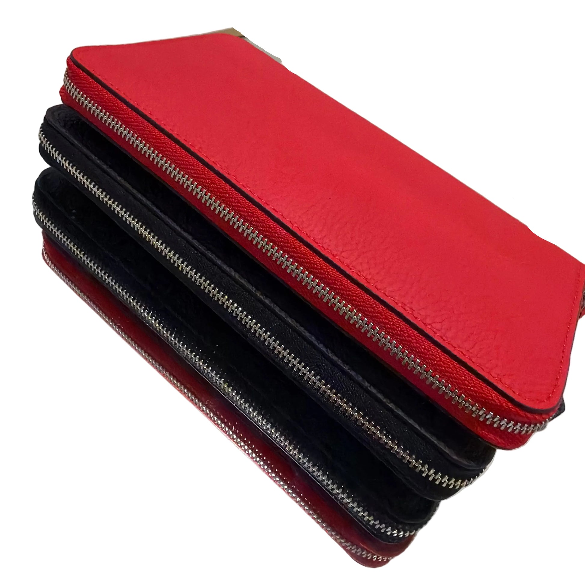 Red and black leather bags with zippers on a white surface