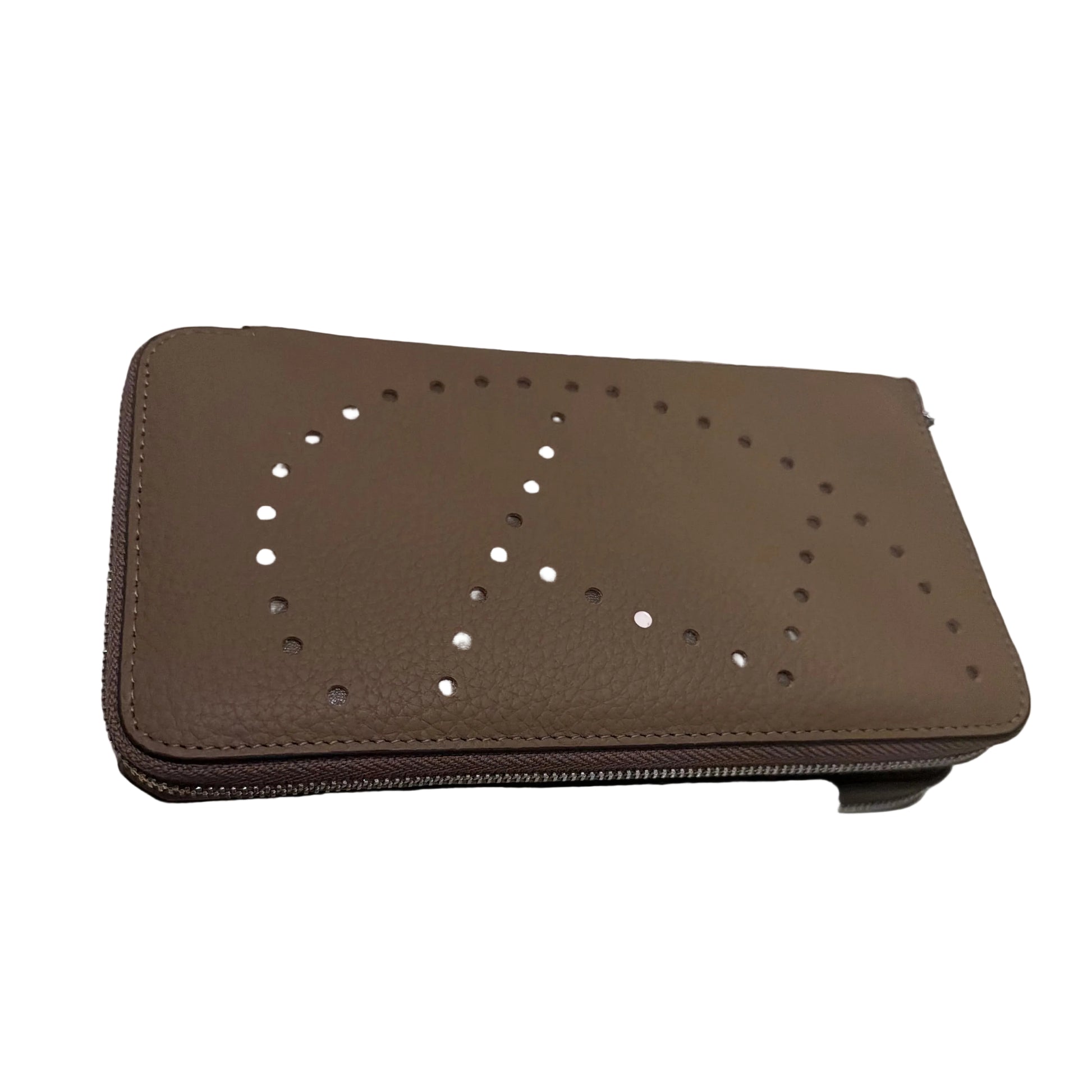 Brown perforated wallet on a glass surface with a white tiled wall background
