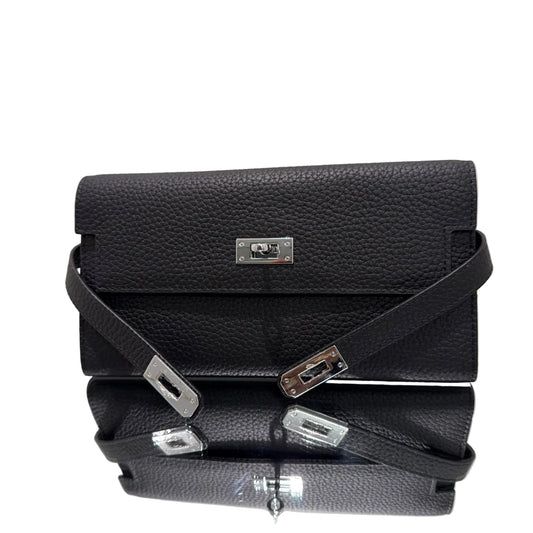 Black leather handbag with silver hardware on a light gray background