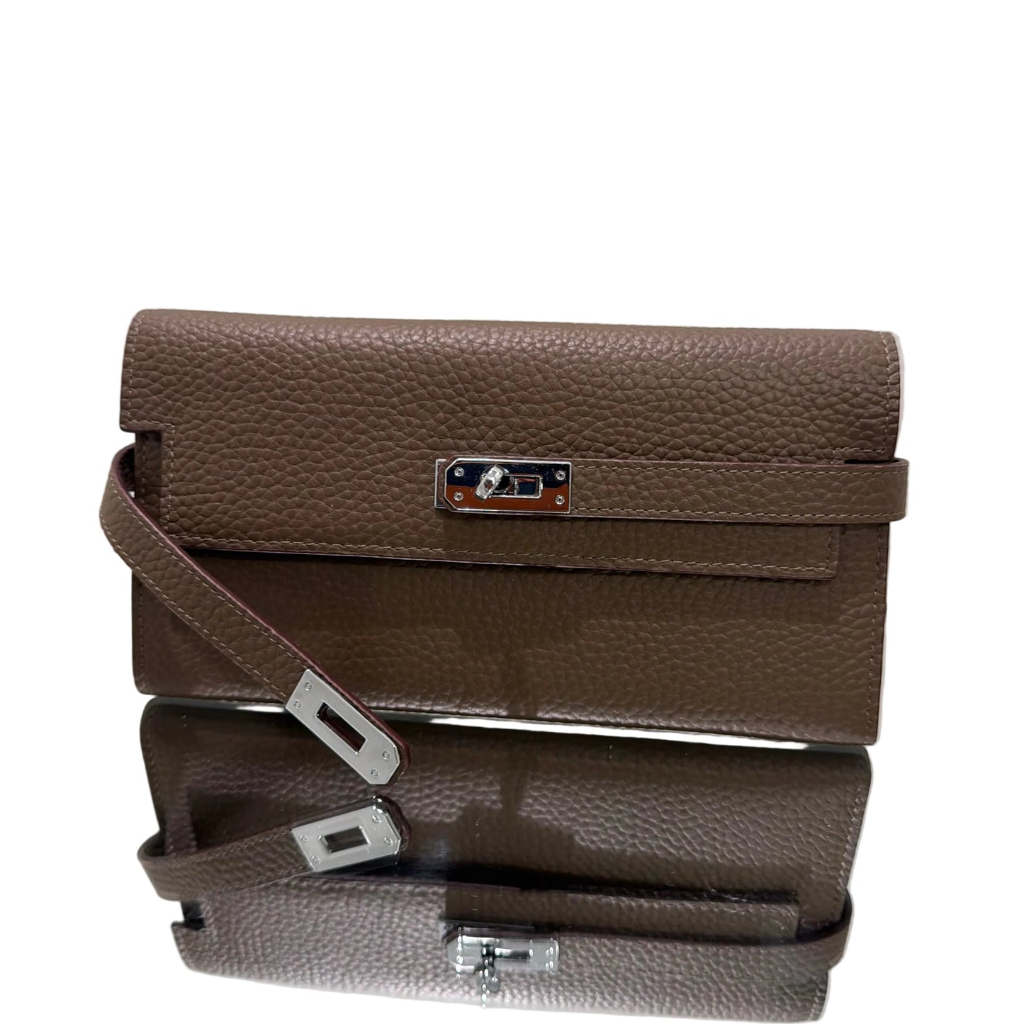 Brown leather handbag with a strap on a light gray background