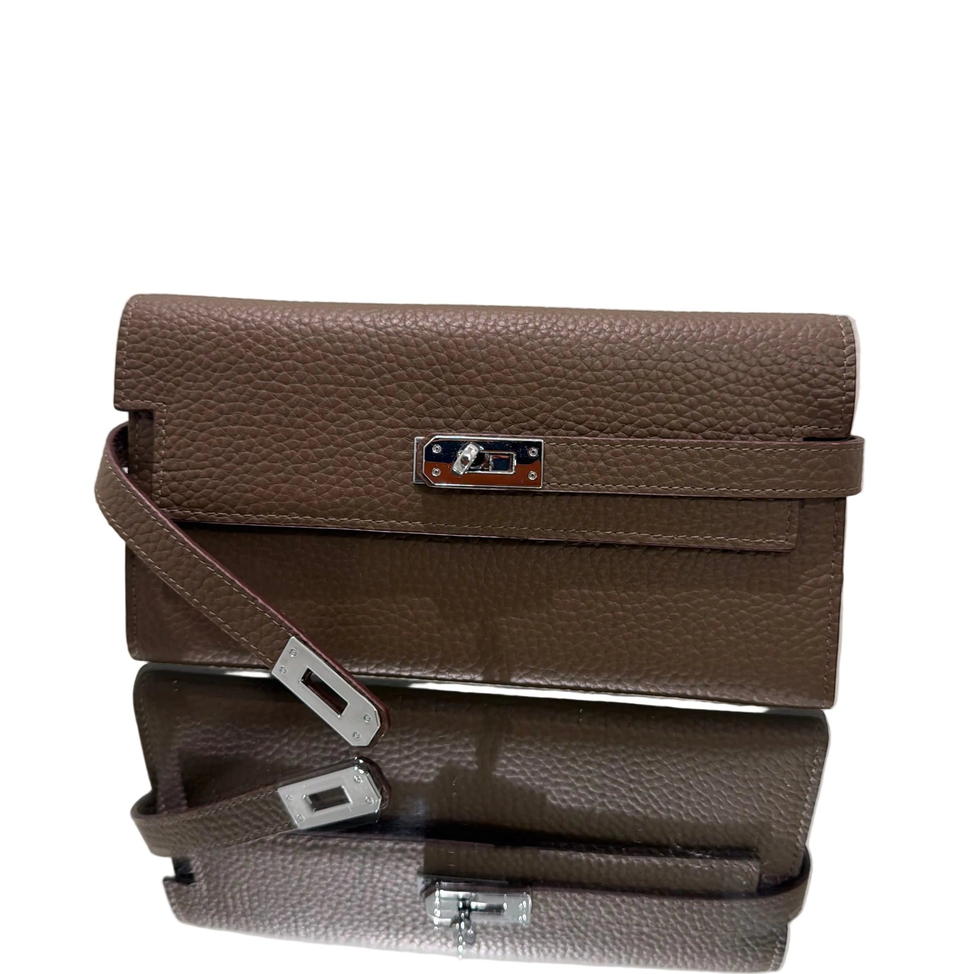 Brown leather handbag with a strap on a light gray background