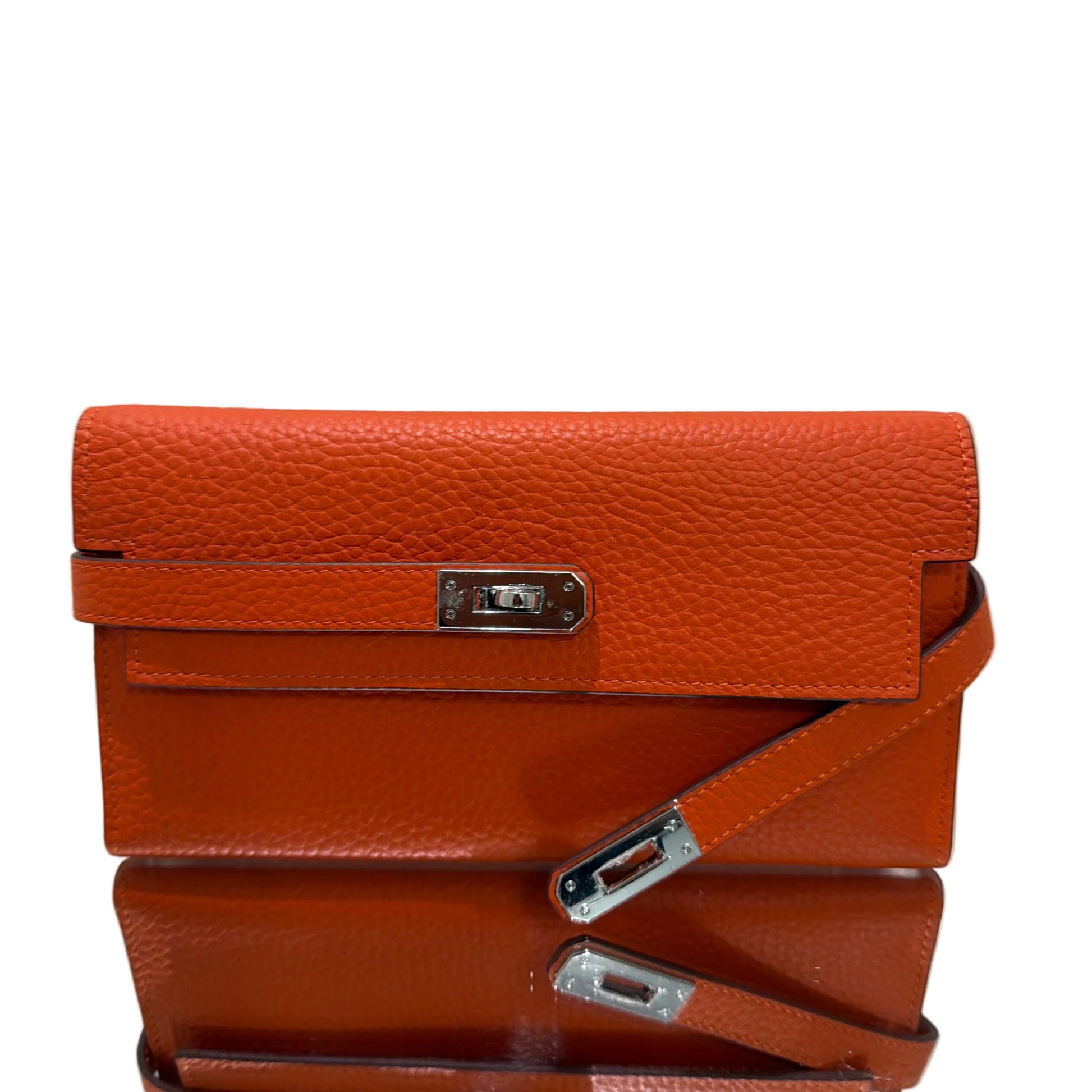 Brown leather handbag with silver hardware on a light gray background