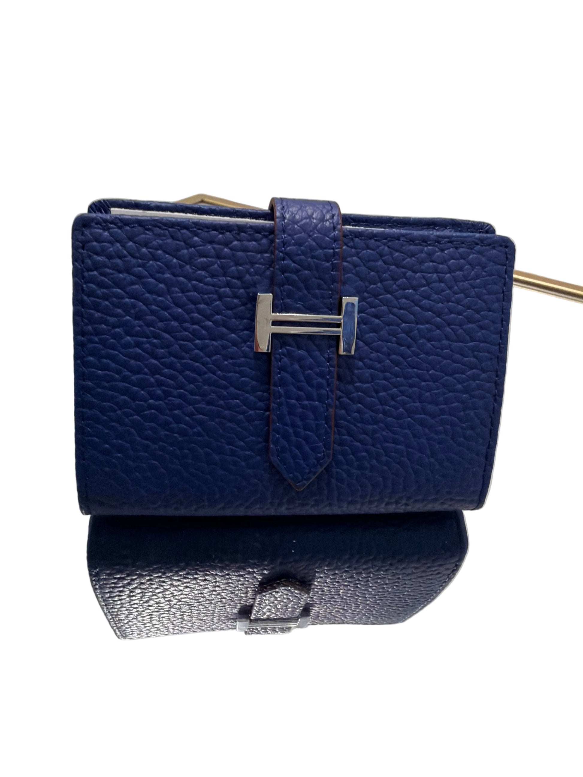 Blue textured wallet with silver buckle on a clear stand