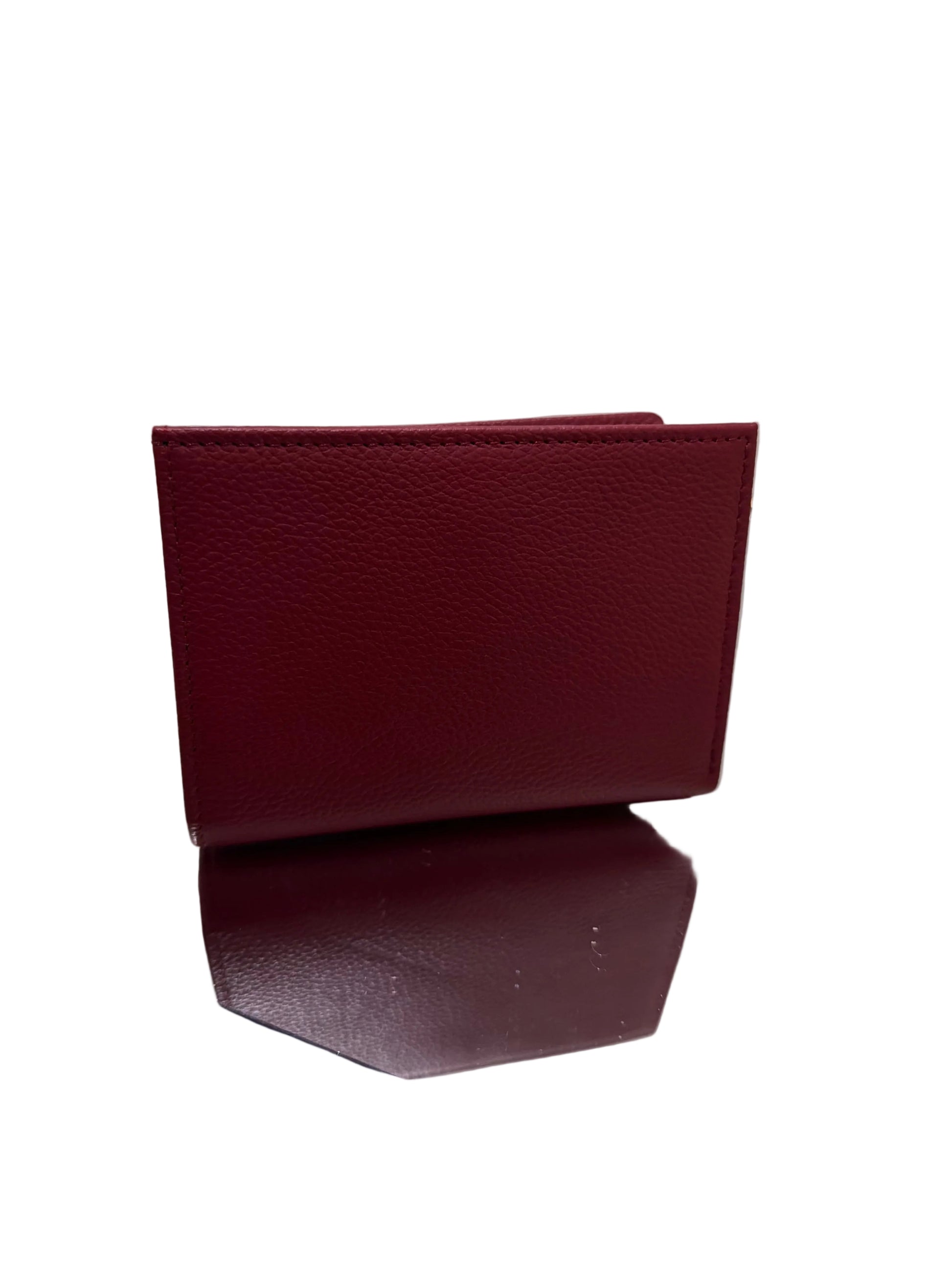 Two burgundy leather journals on a white surface with a gold stand.