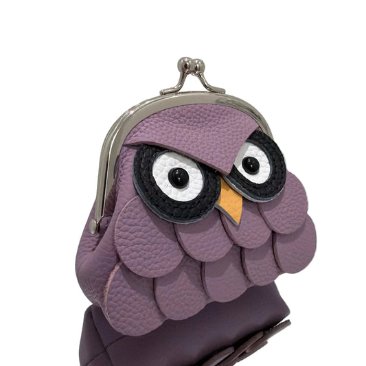 Purple owl-shaped coin purse on a white surface