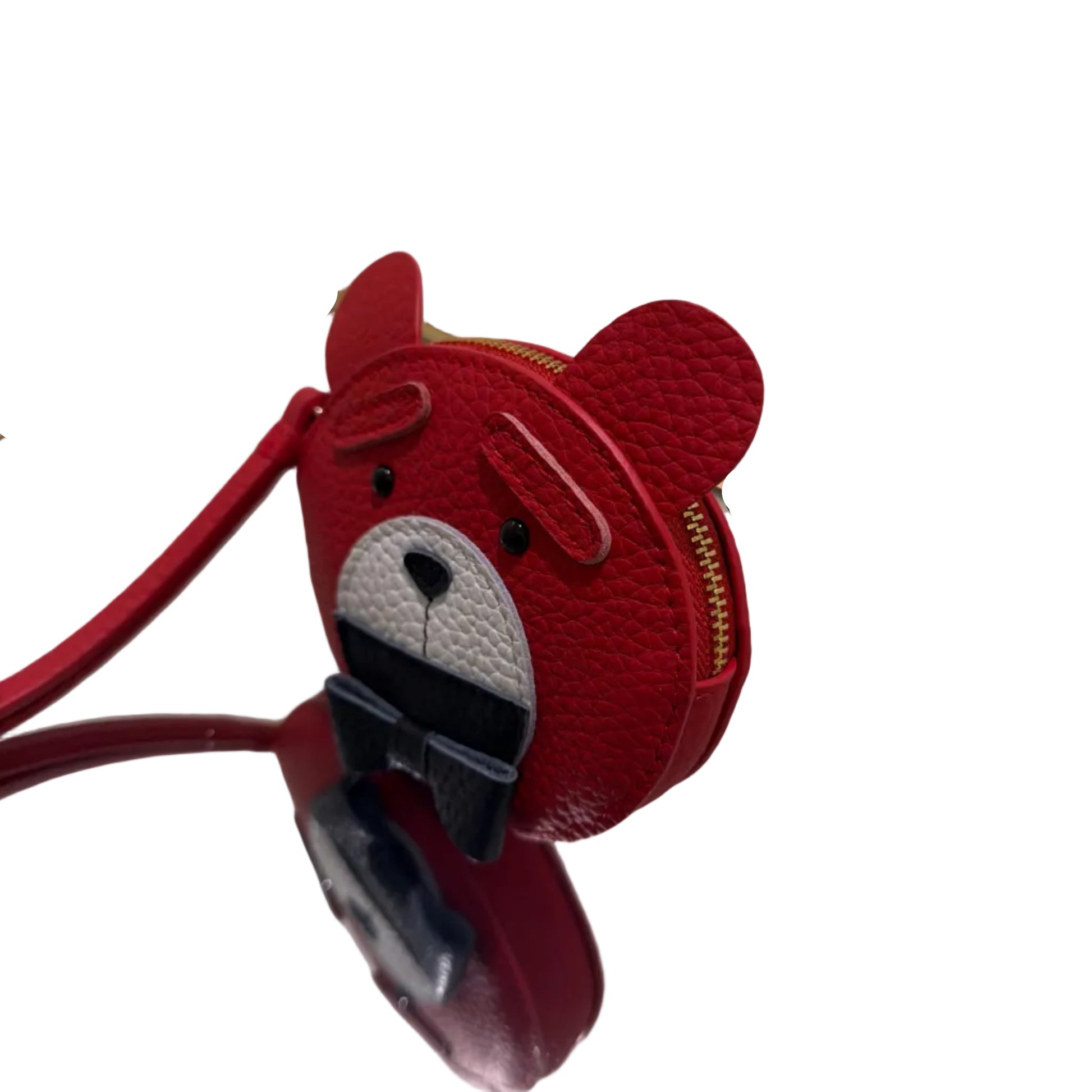 Red bear-shaped phone case with a black strap on a reflective surface