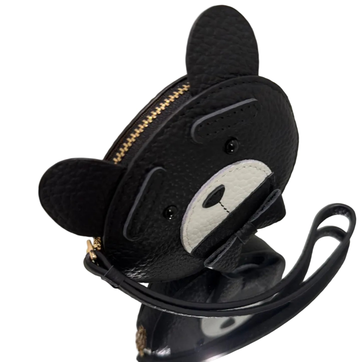 Black pouch with a cartoon face design on a reflective surface