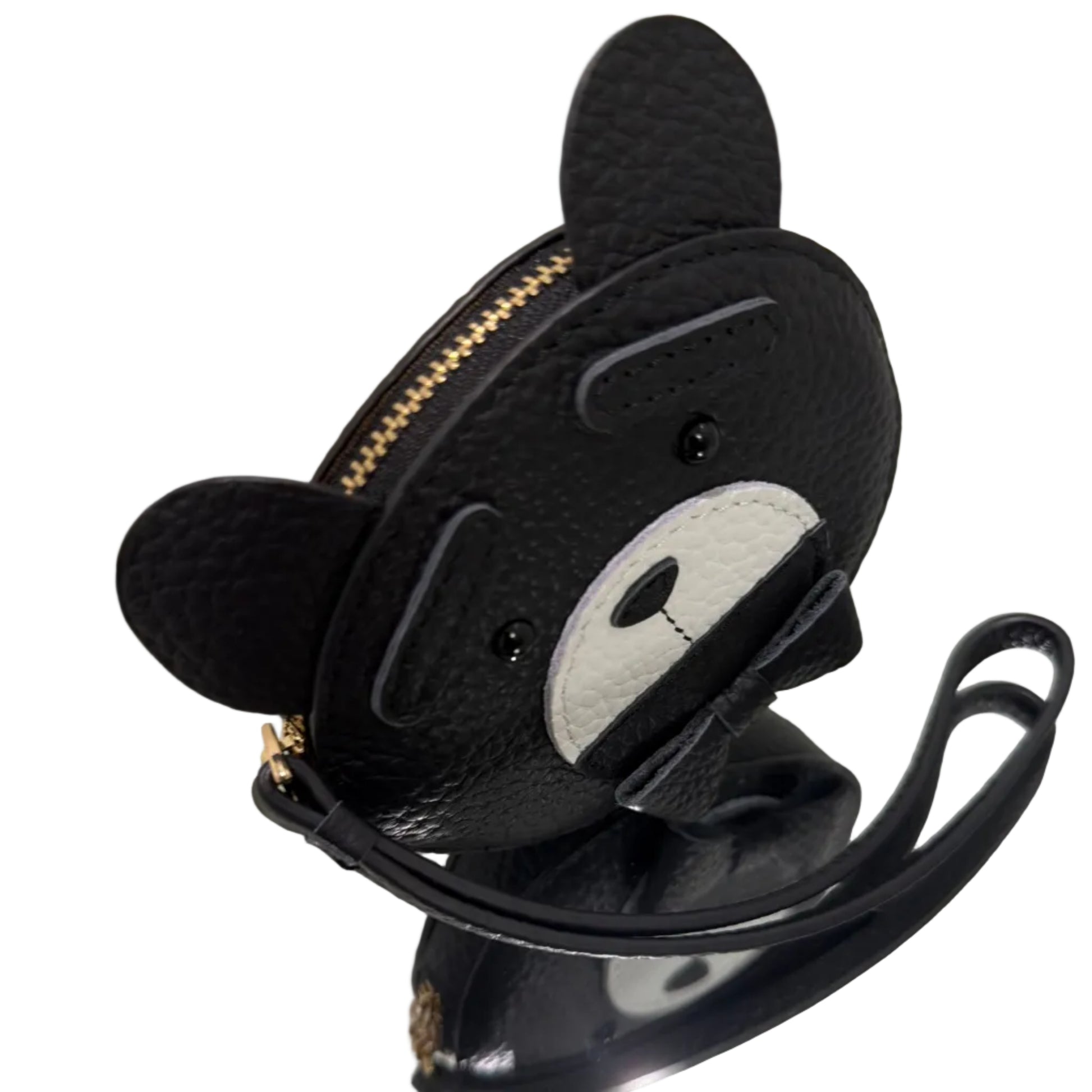 Black pouch with a cartoon face design on a reflective surface