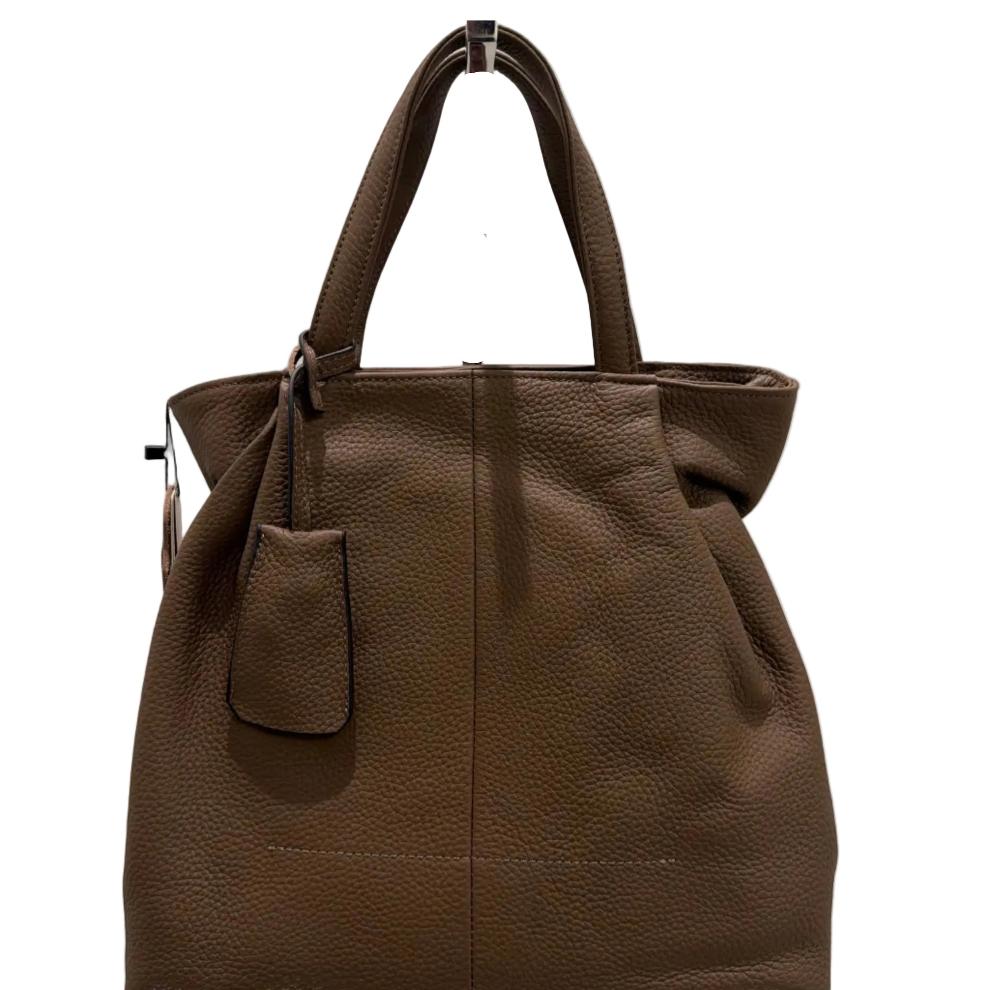 Brown leather tote bag on a light beige surface with a mirror reflection.