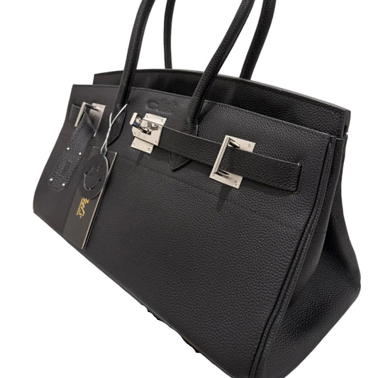 Black leather handbag with gold hardware on a light background