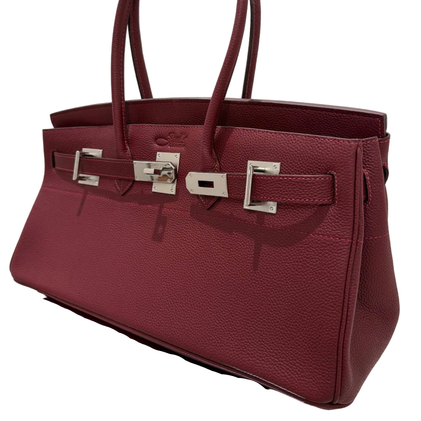 Maroon handbag with silver hardware on a white background