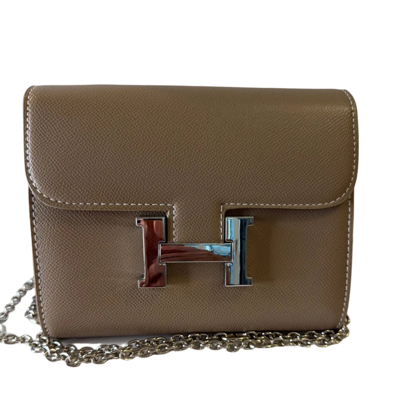 Beige handbag with a chain strap on a light background