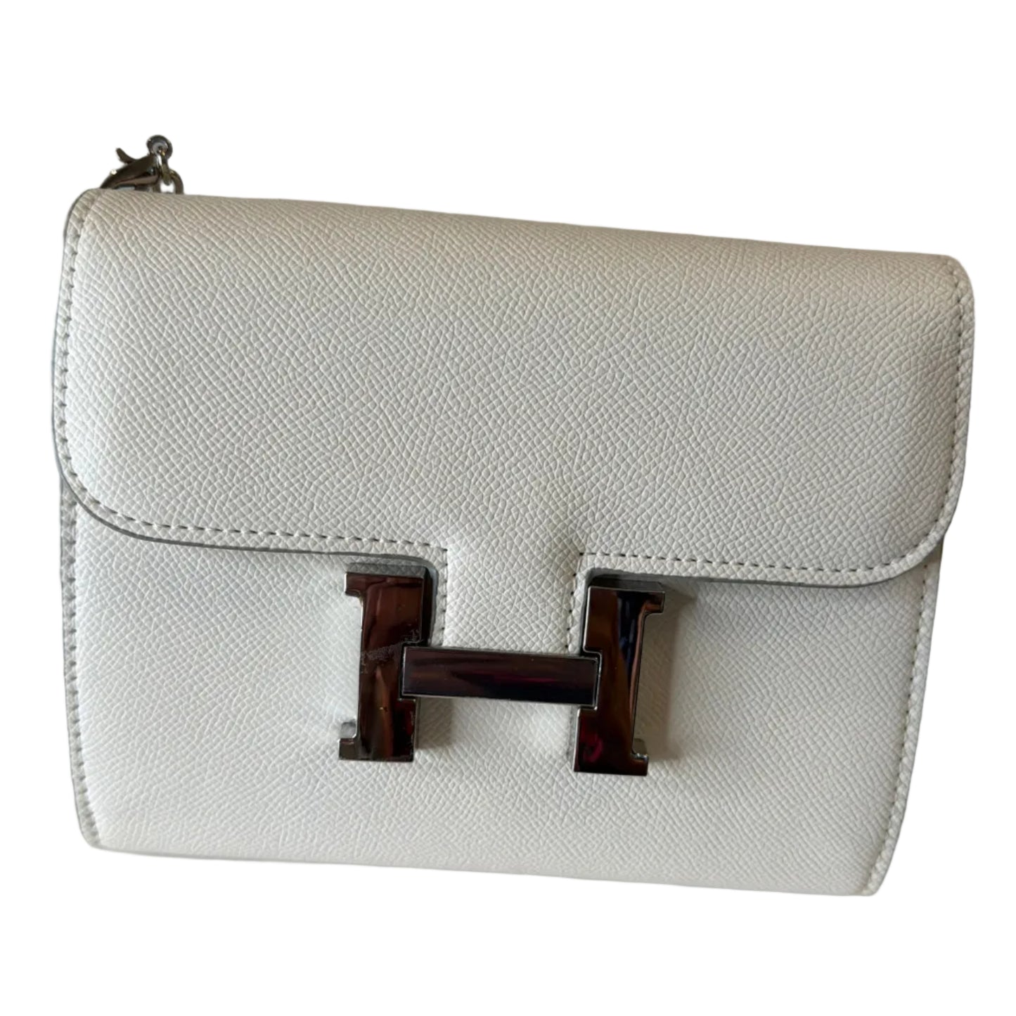 White handbag with a gold clasp on a light gray background