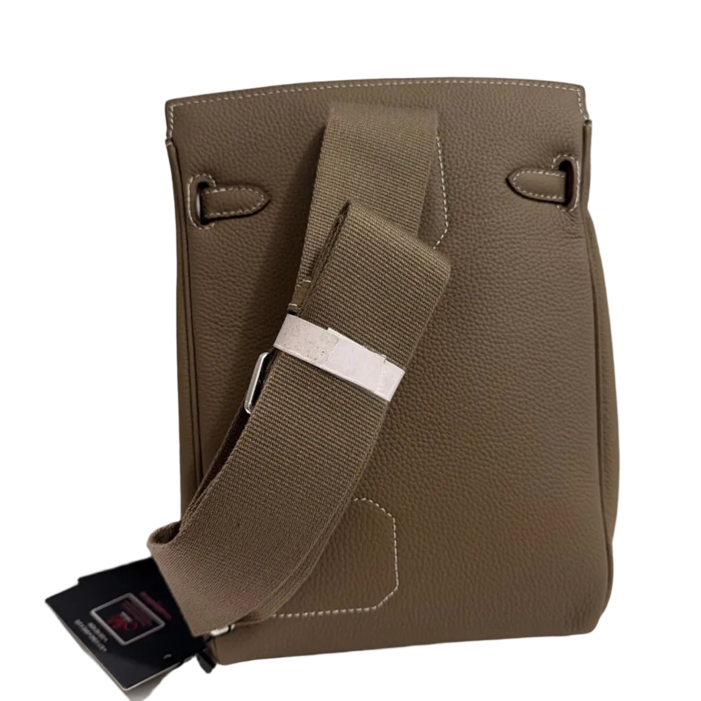 Brown leather bag with a strap on a light gray background