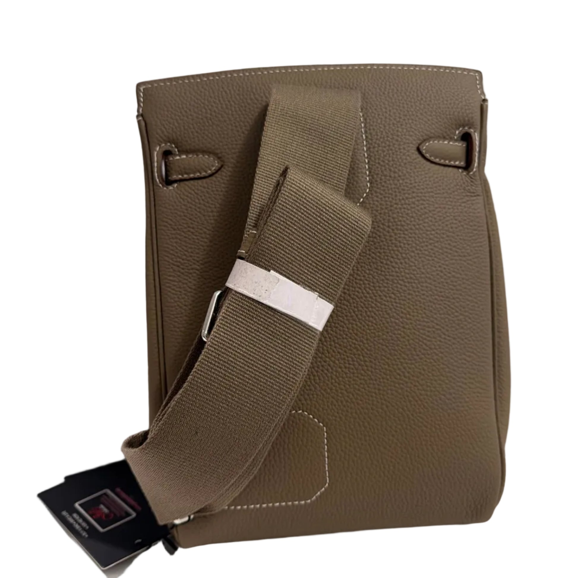 Brown leather bag with a strap on a light gray background