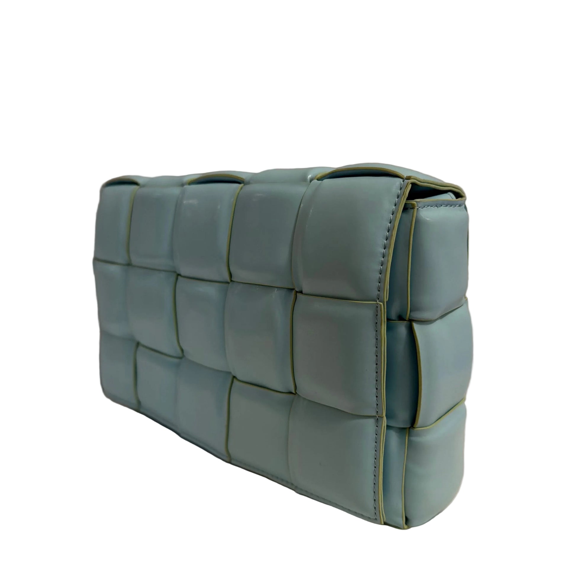 Light blue quilted bag on a beige surface