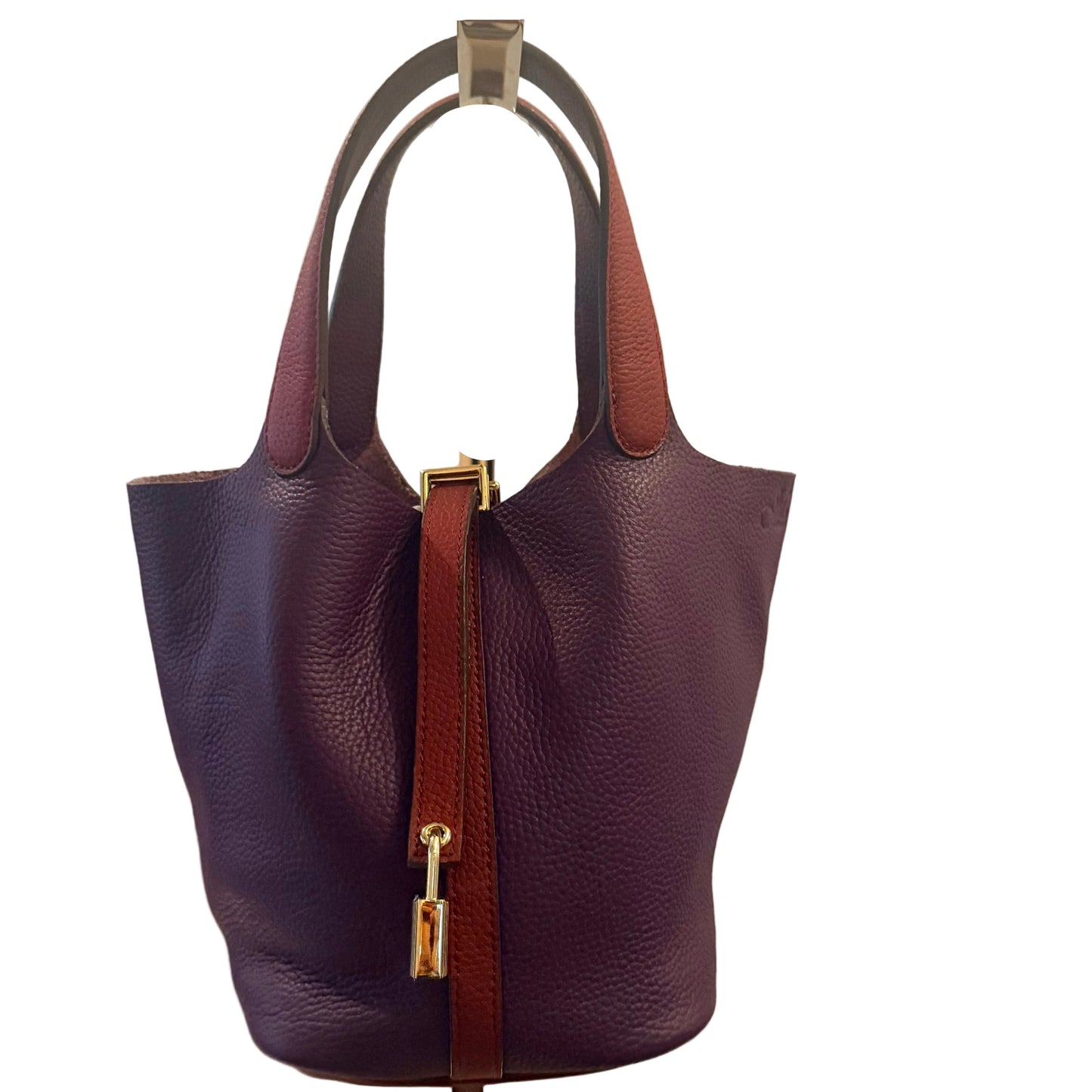 Purple handbag with brown strap on a beige background