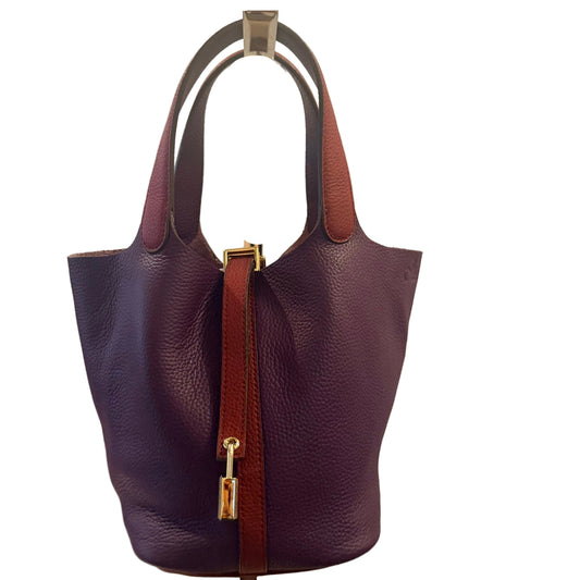 Purple handbag with brown strap on a beige background