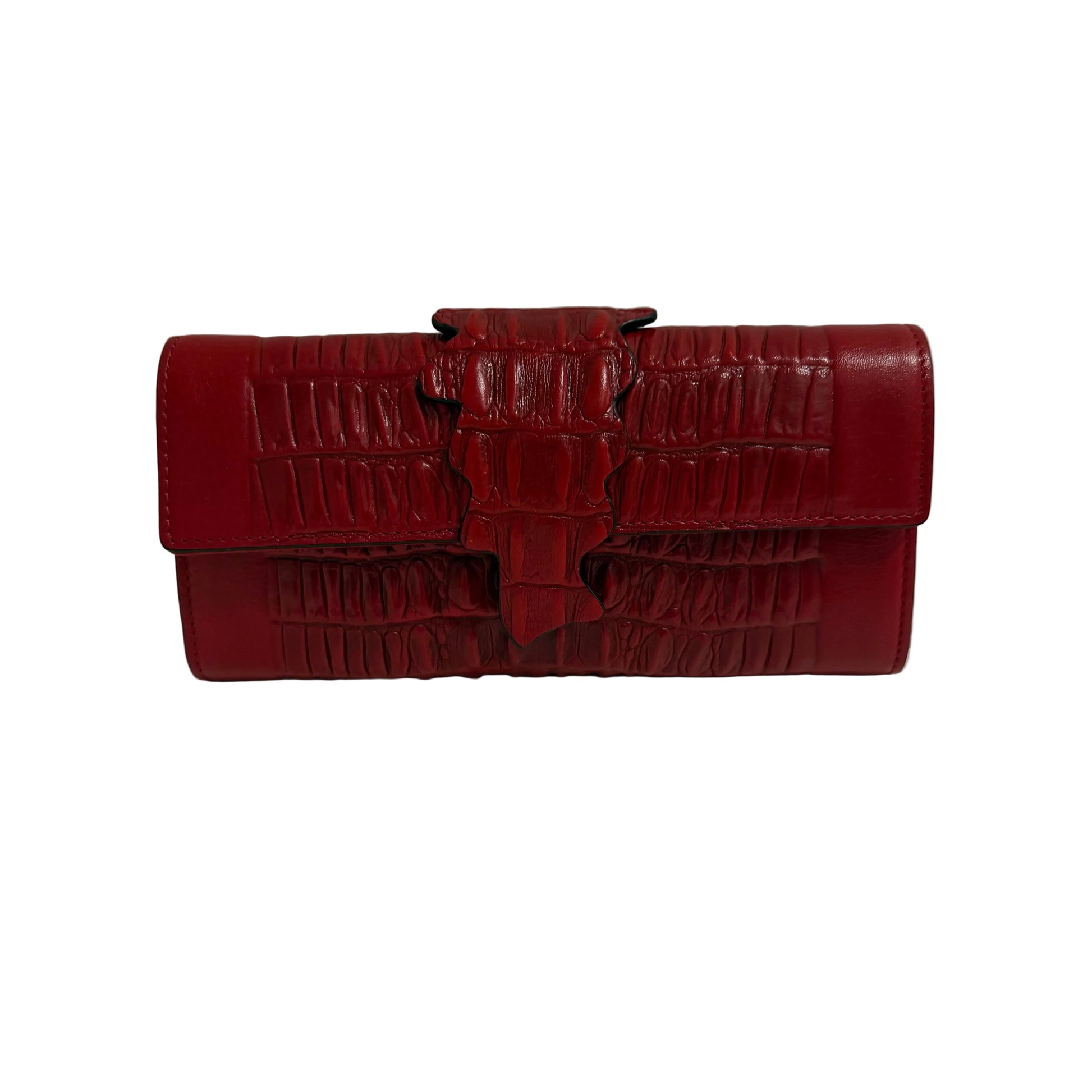Red crocodile-patterned handbag on a white surface with a gray background