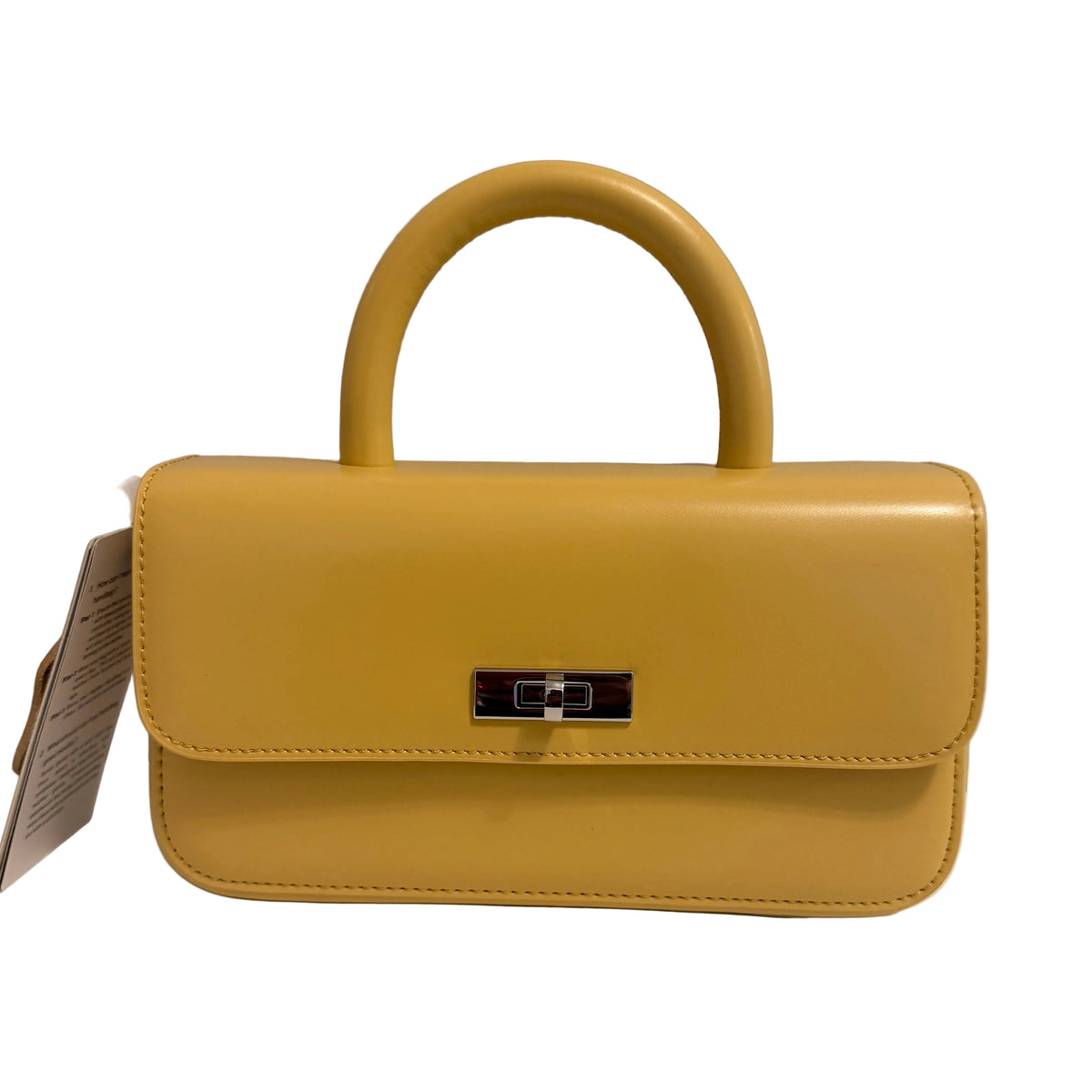 A mustard yellow structured handbag with a top handle and a small black metal accent, photographed against a plain light gray background.