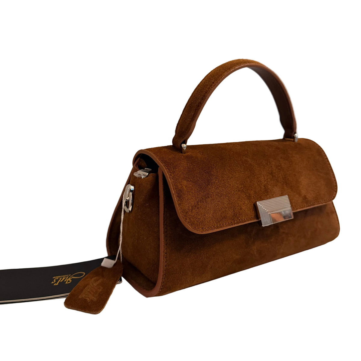 A brown suede handbag with a top handle, a zippered side pocket, and a silver-tone metal clasp, displayed on a white surface against a light gray wall.
