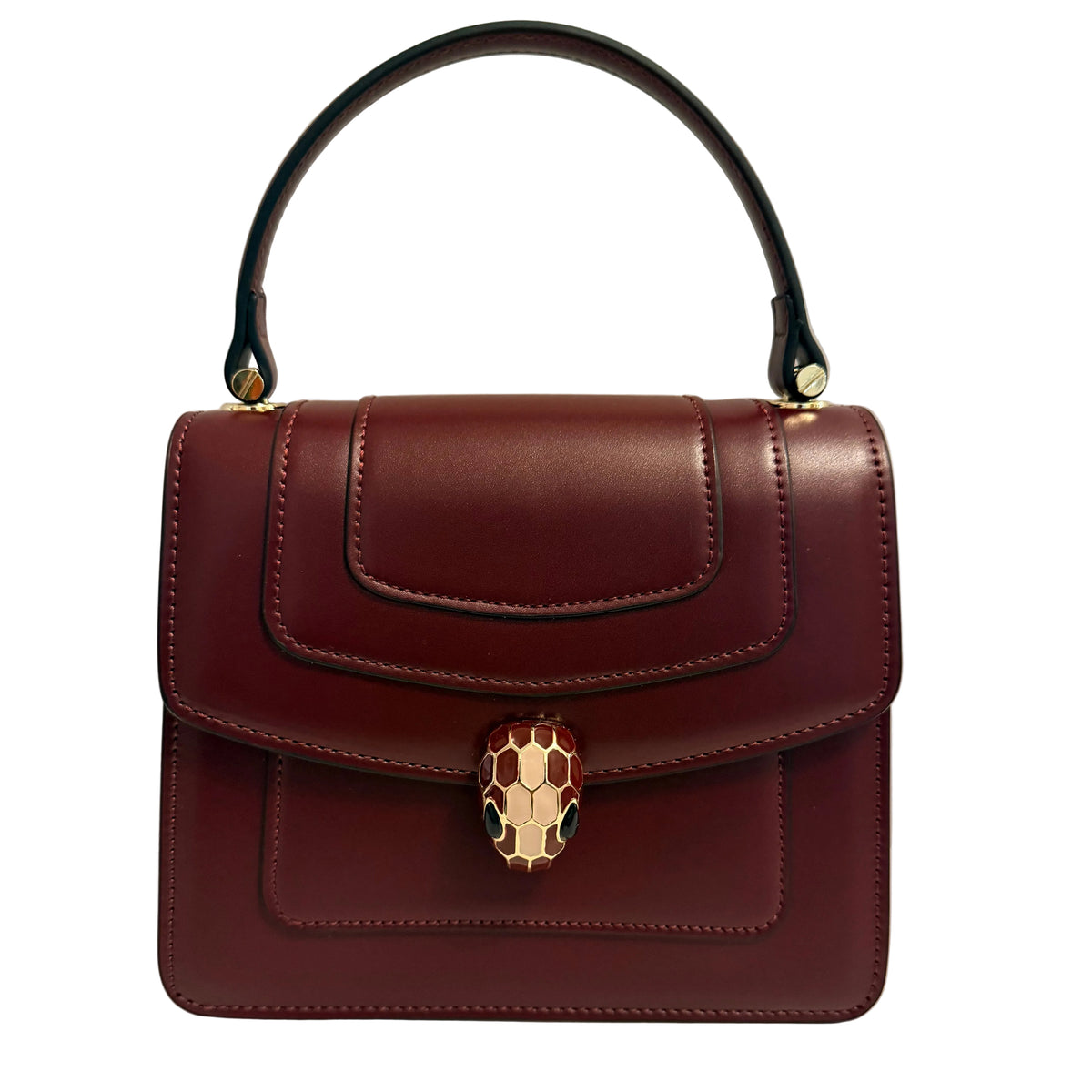 A structured burgundy leather handbag with a top handle, featuring a gold-tone snake head clasp on the front flap, photographed against a plain light background.