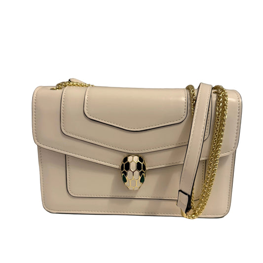 A white leather shoulder bag with a gold chain strap and a distinctive snake head clasp, displayed on a white surface against a neutral gray background.