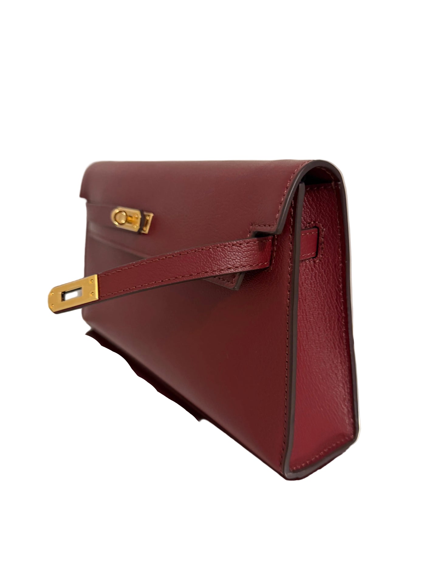 Brown leather handbag with gold hardware on a light background