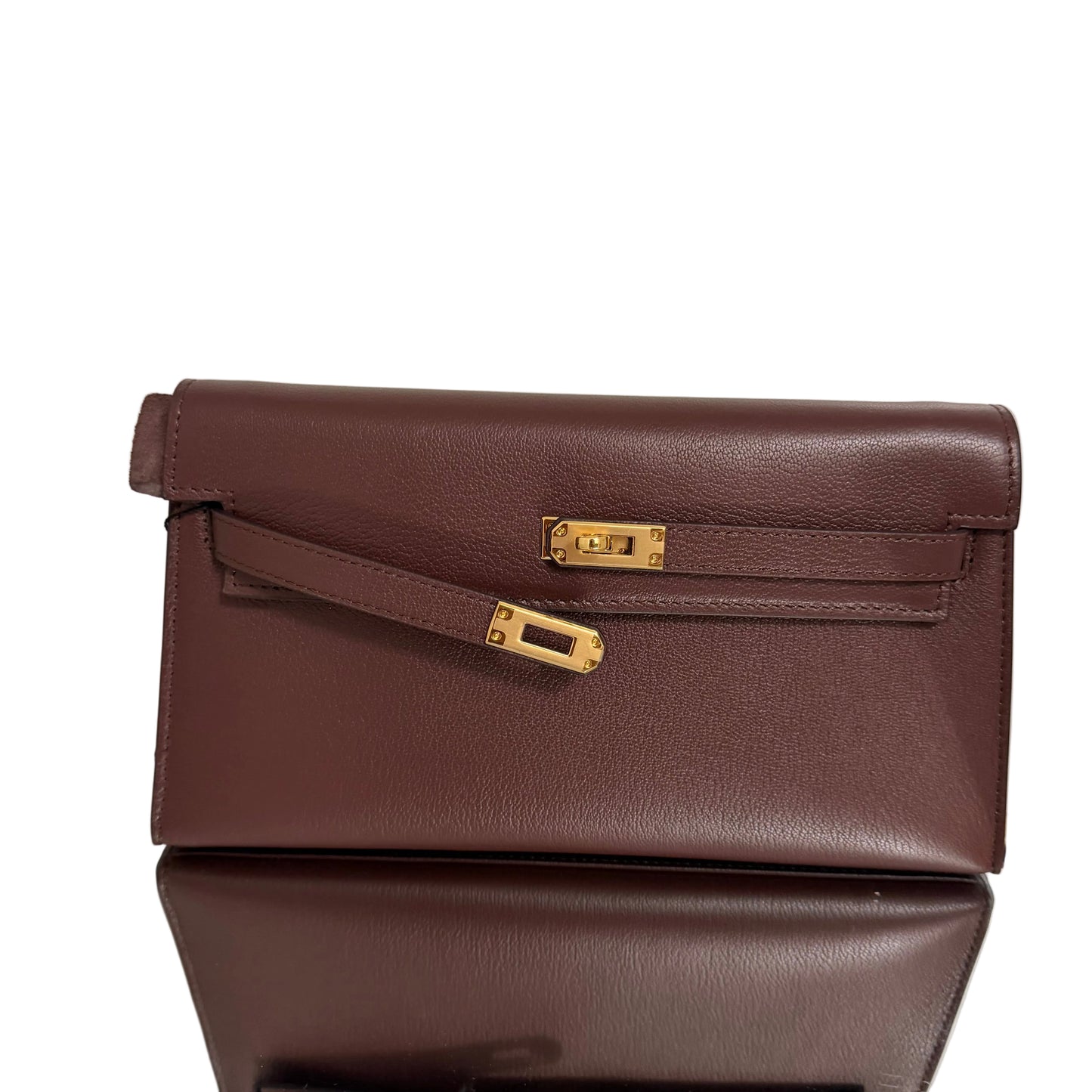 Brown leather clutch with gold accents on a light background