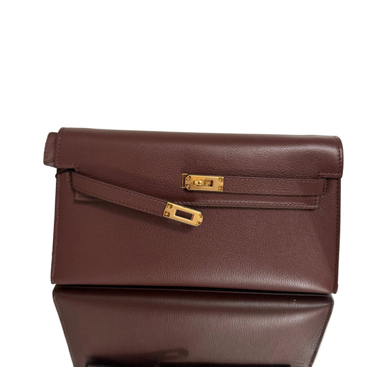 Brown leather clutch with gold accents on a light background