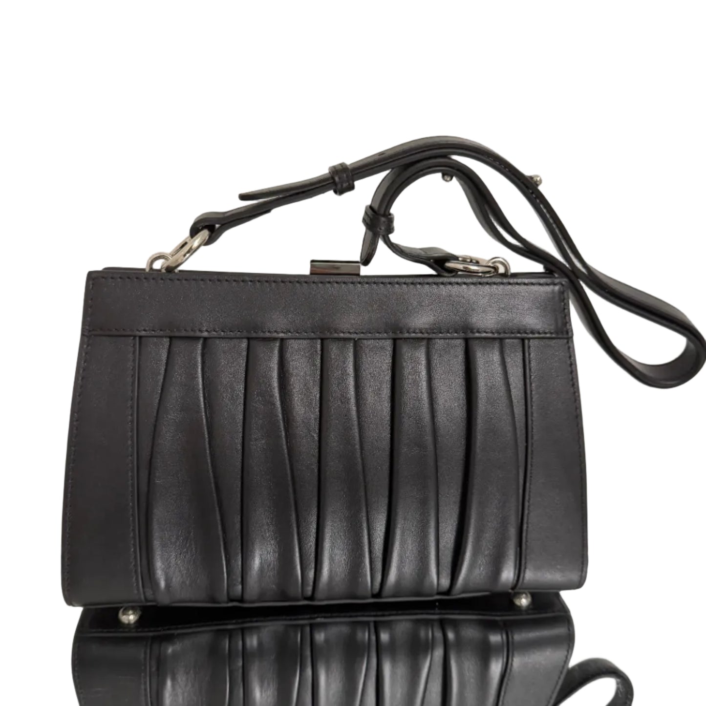 Black leather handbag with a strap on a light background