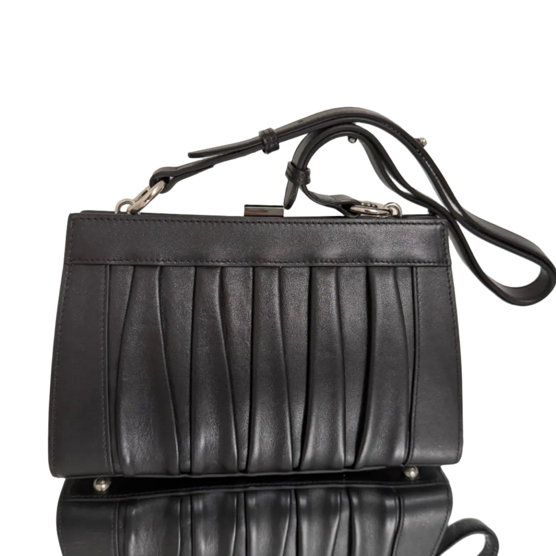 Black leather handbag with a strap on a light background