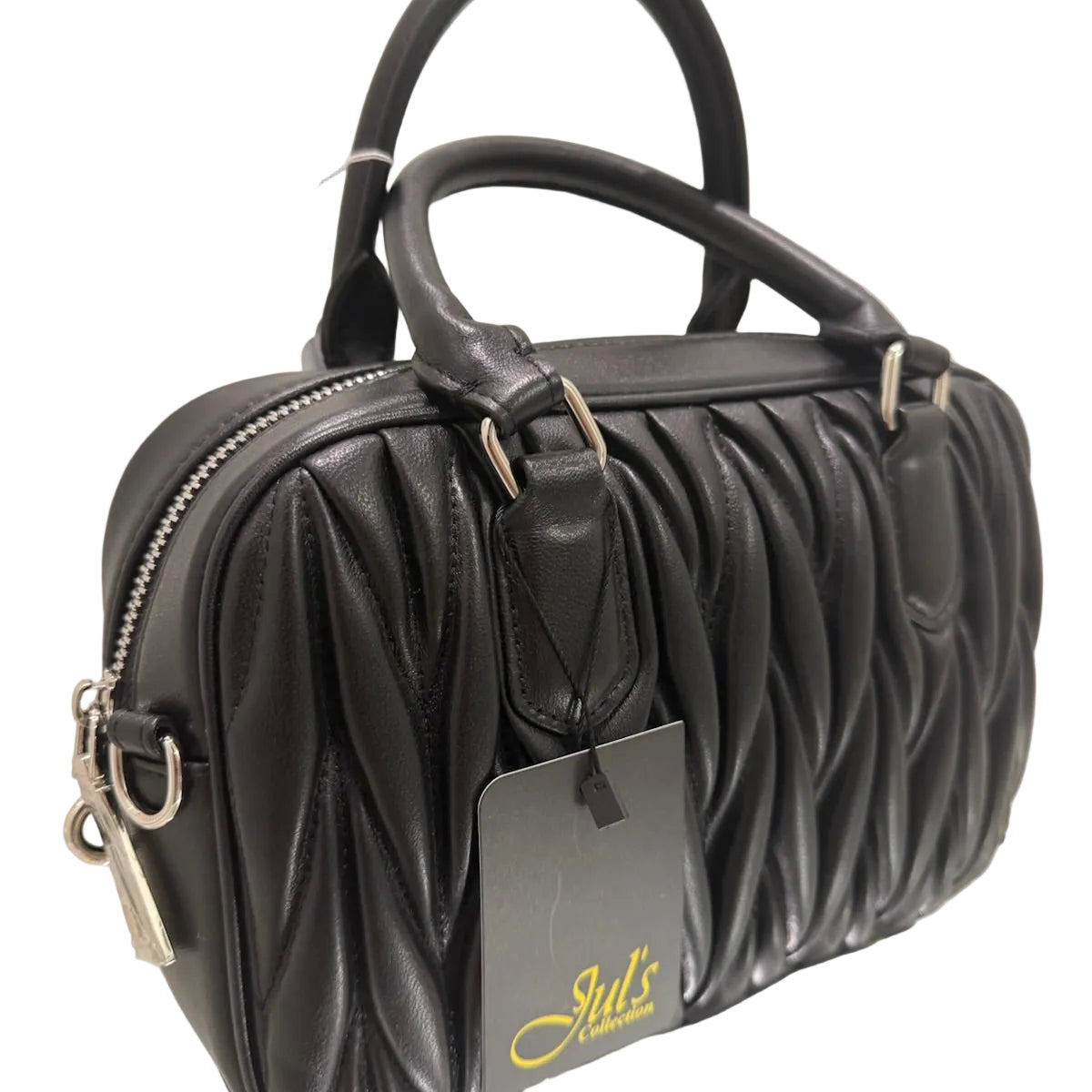 Black quilted handbag with a visible brand tag on a reflective surface.