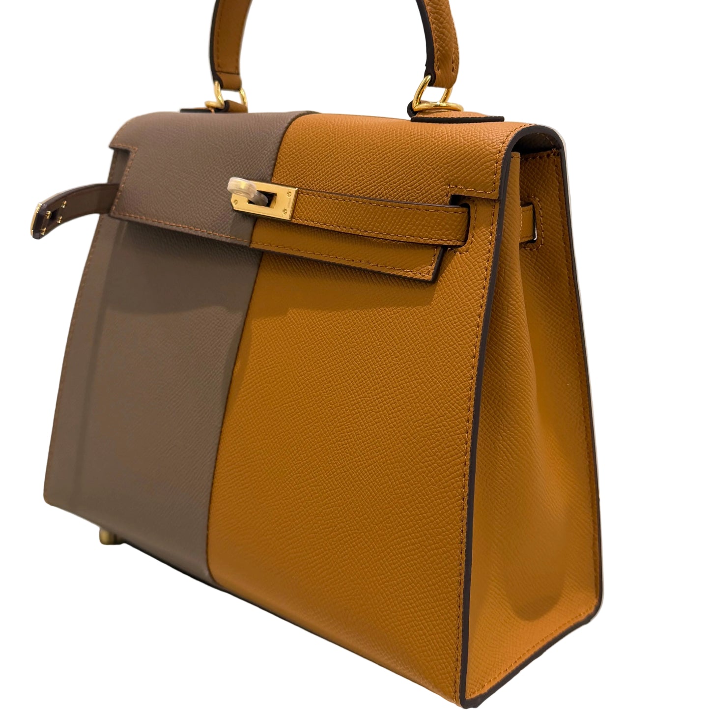 Brown and gray handbag with gold accents on a light beige background