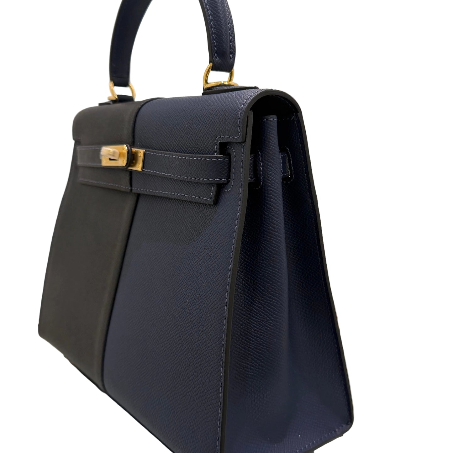 Navy blue handbag with gold accents on a light gray background