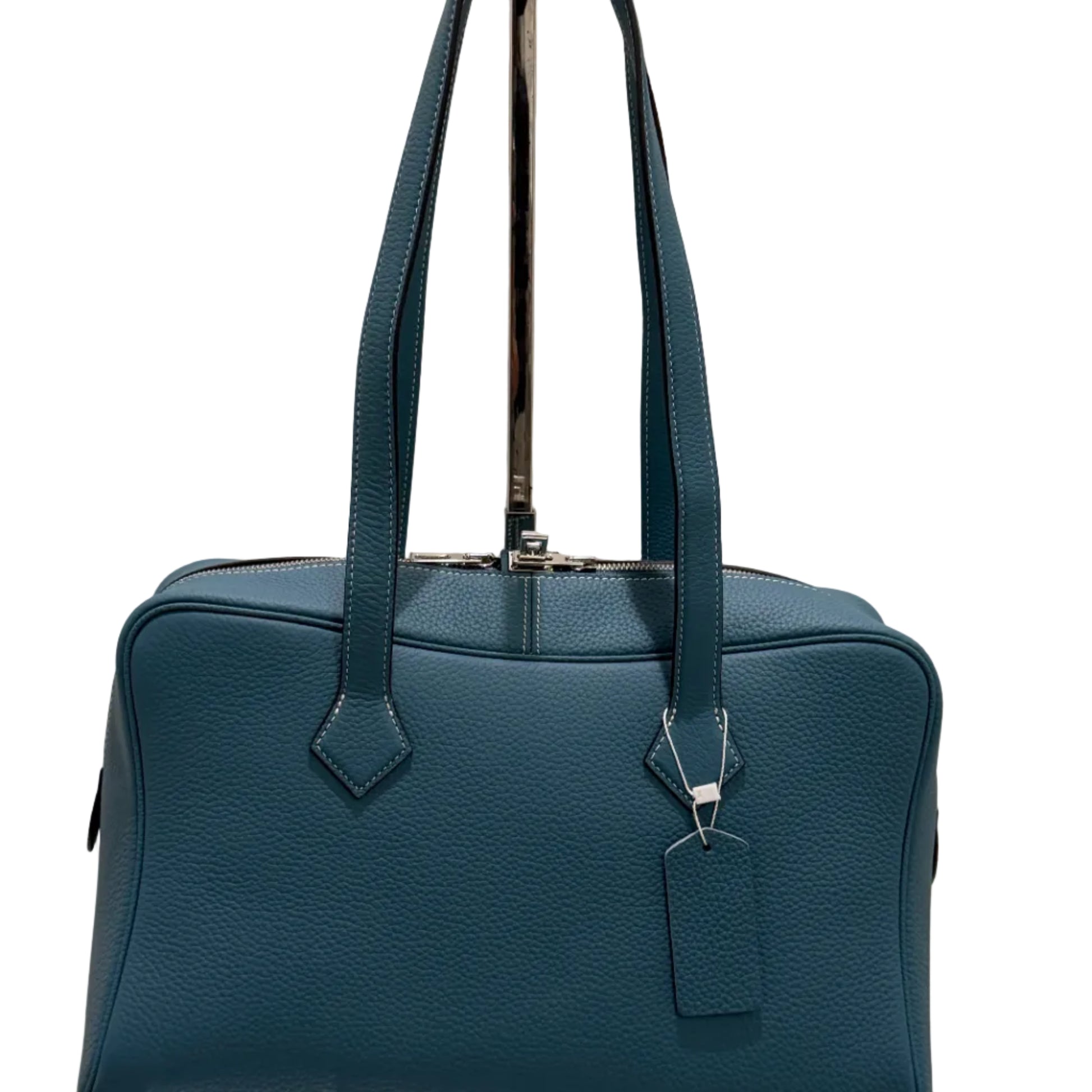 Blue handbag with a metallic clasp on a light background