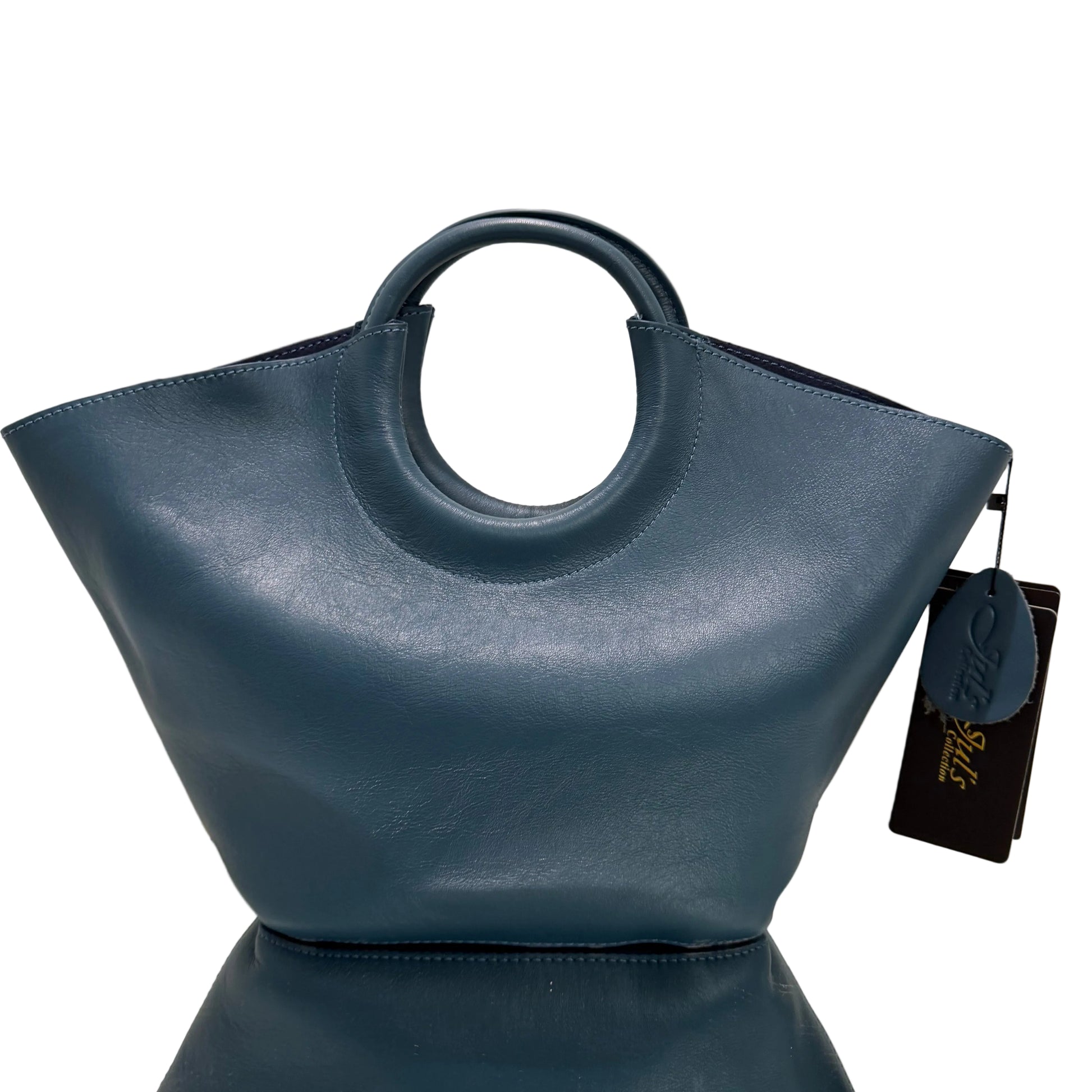 Blue leather handbag with circular handle on a light background